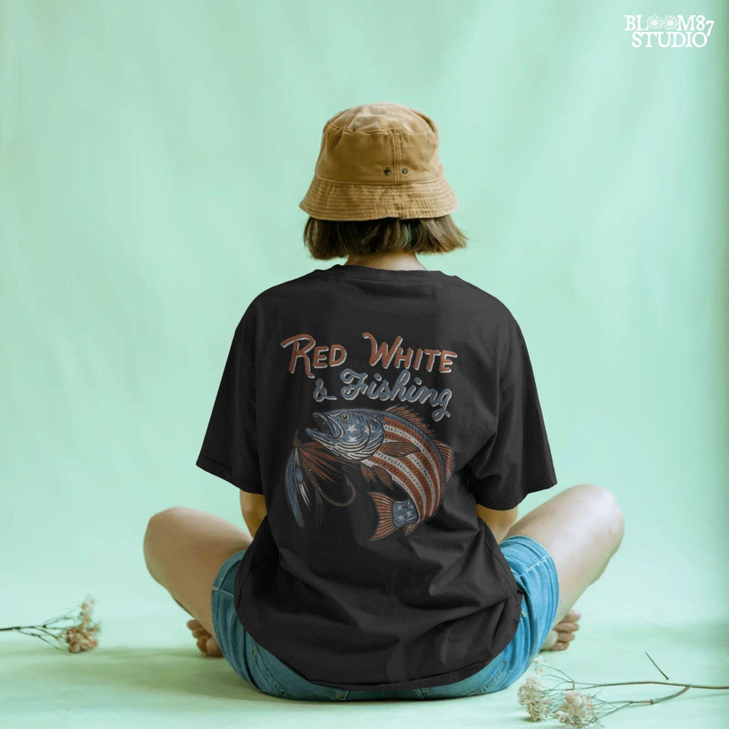 Bass fish decorated with American flag stars and stripes, jumping with a fishing lure and text “Red White & Fishing” in patriotic style.