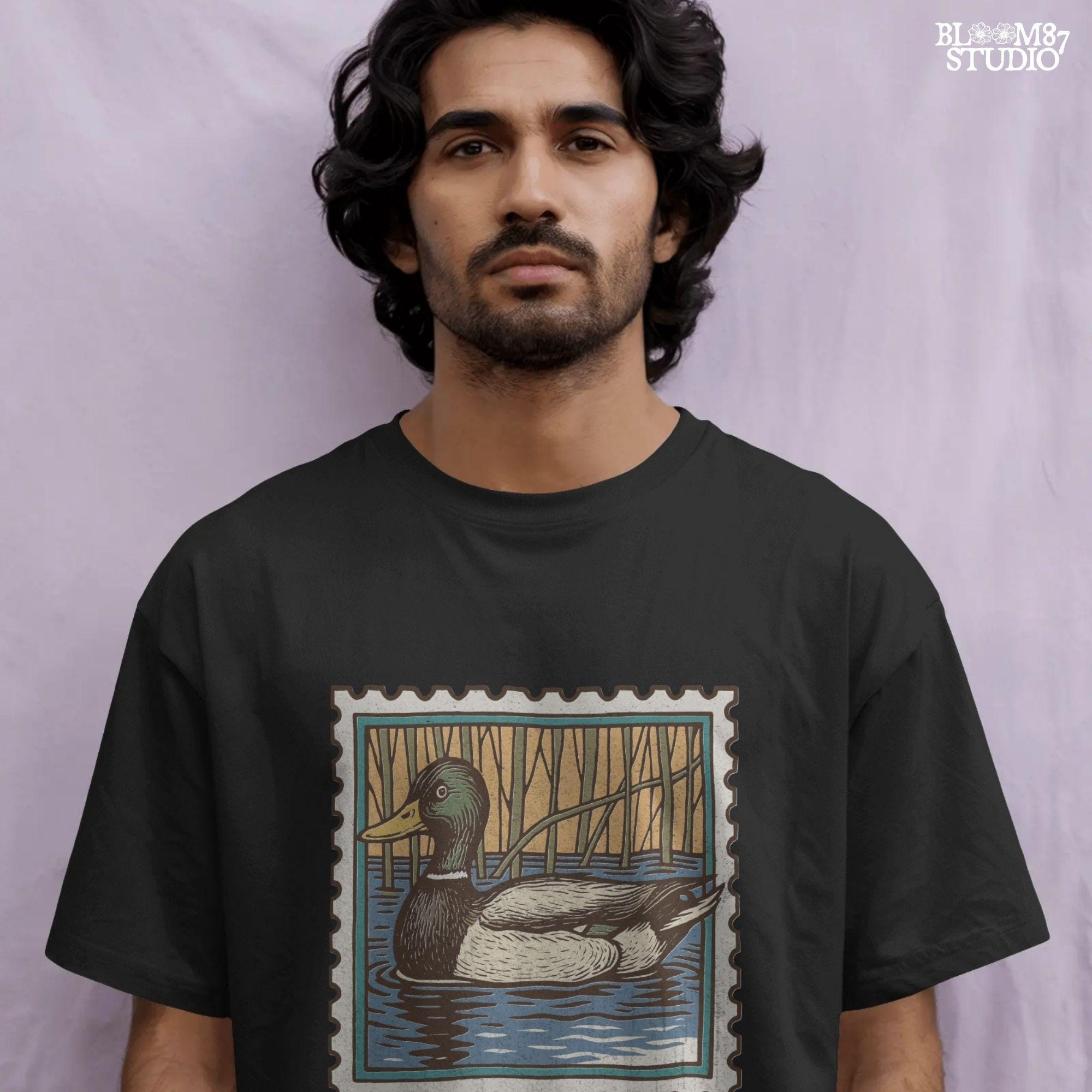 Vintage stamp-style mallard duck floating in water with forest background and text “Duck Season – Southern Made” in retro serif font.