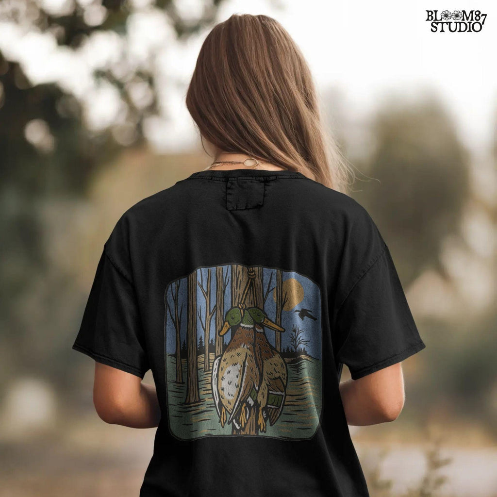 Illustration of two mallard ducks hanging from a tree in a flooded timber swamp at sunset, designed for duck hunting-themed sublimation and lodge decor.