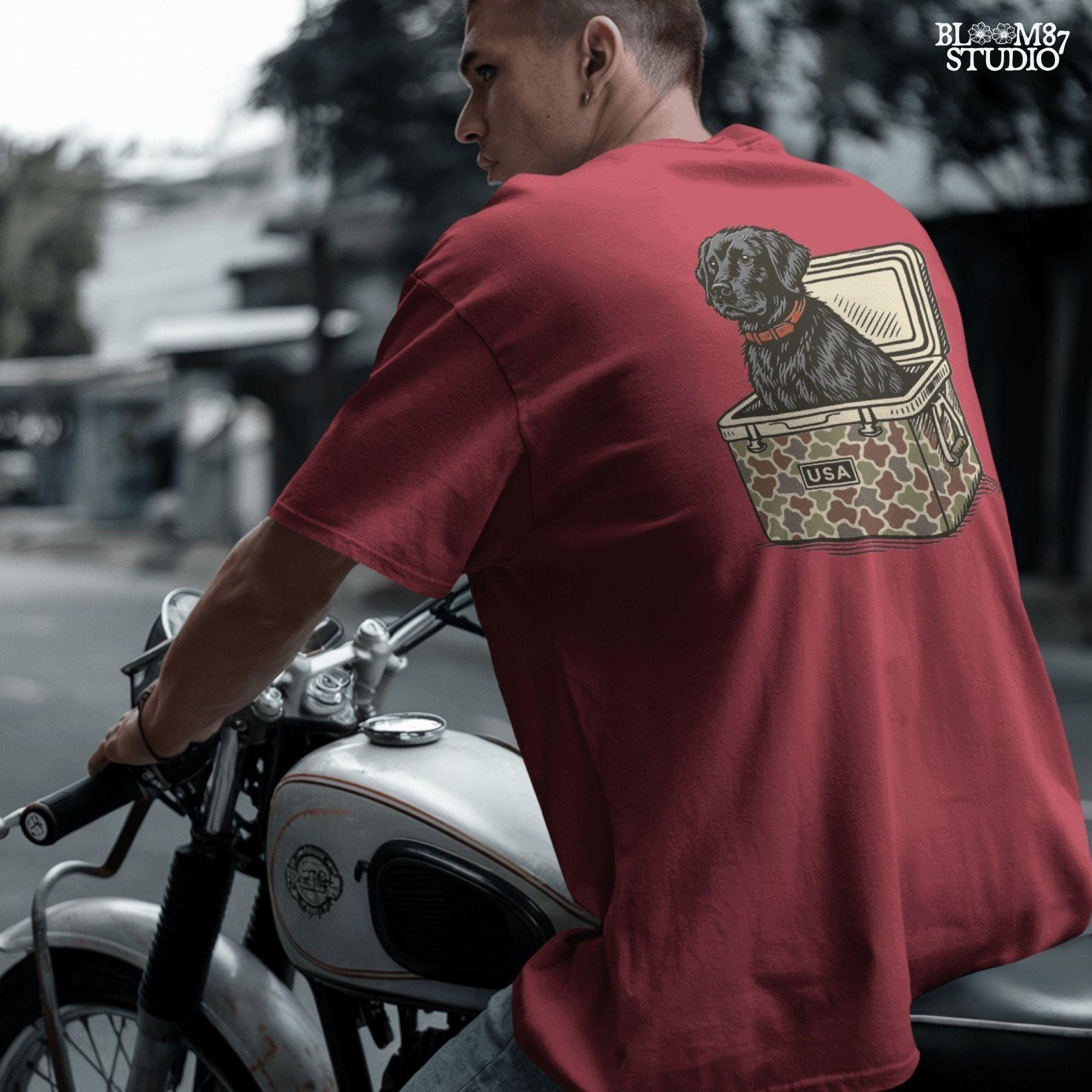 Hand-drawn black Labrador retriever sitting in a camouflage cooler labeled “USA,” designed for sublimation and hunting-themed merchandise.