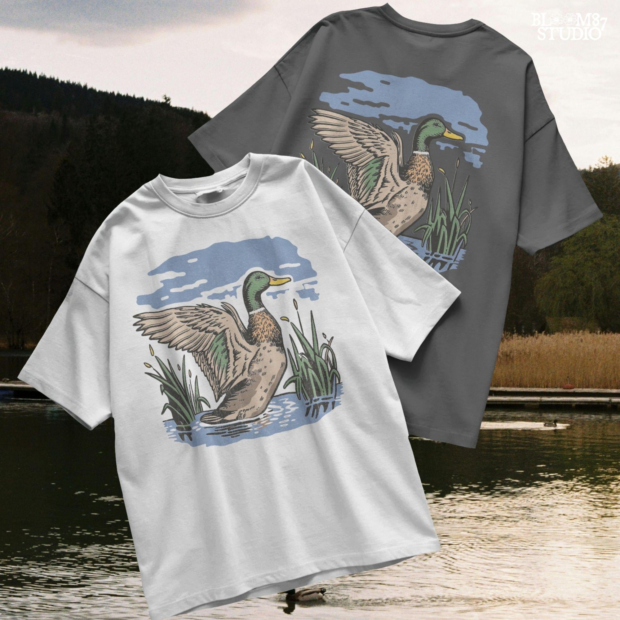 Vintage illustration of a mallard duck with wings spread standing in a pond with reeds and a cloudy blue sky – rustic nature sublimation PNG.