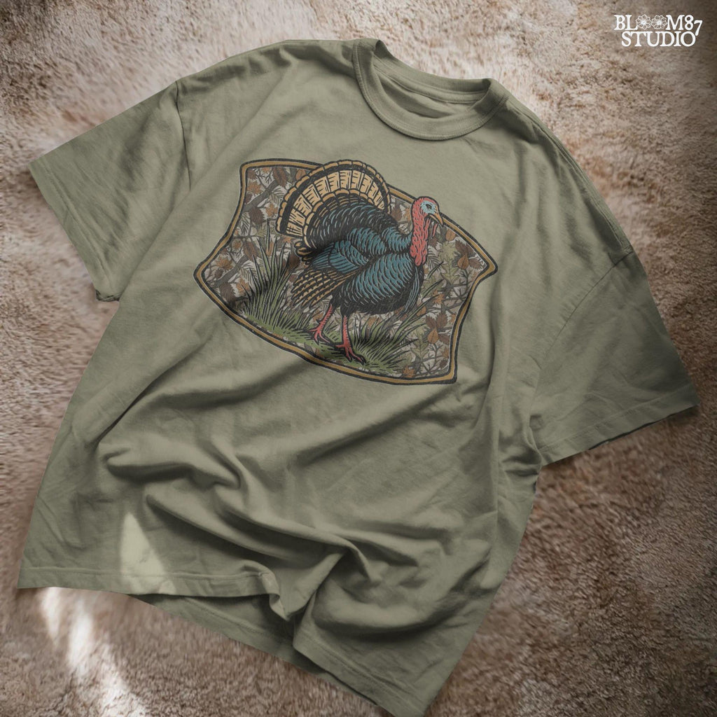 Illustration of a strutting wild turkey in front of a detailed fall camouflage background with brown and orange leaves, designed for sublimation on hunting shirts and Thanksgiving outdoor gear.