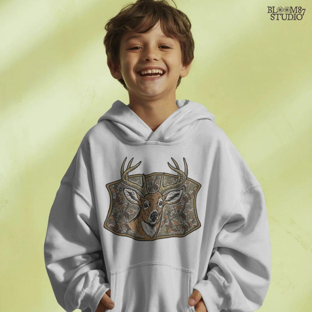 Illustration of a whitetail buck with large antlers in front of a fall forest camo background featuring leaves and branches, perfect for hunting-themed sublimation.