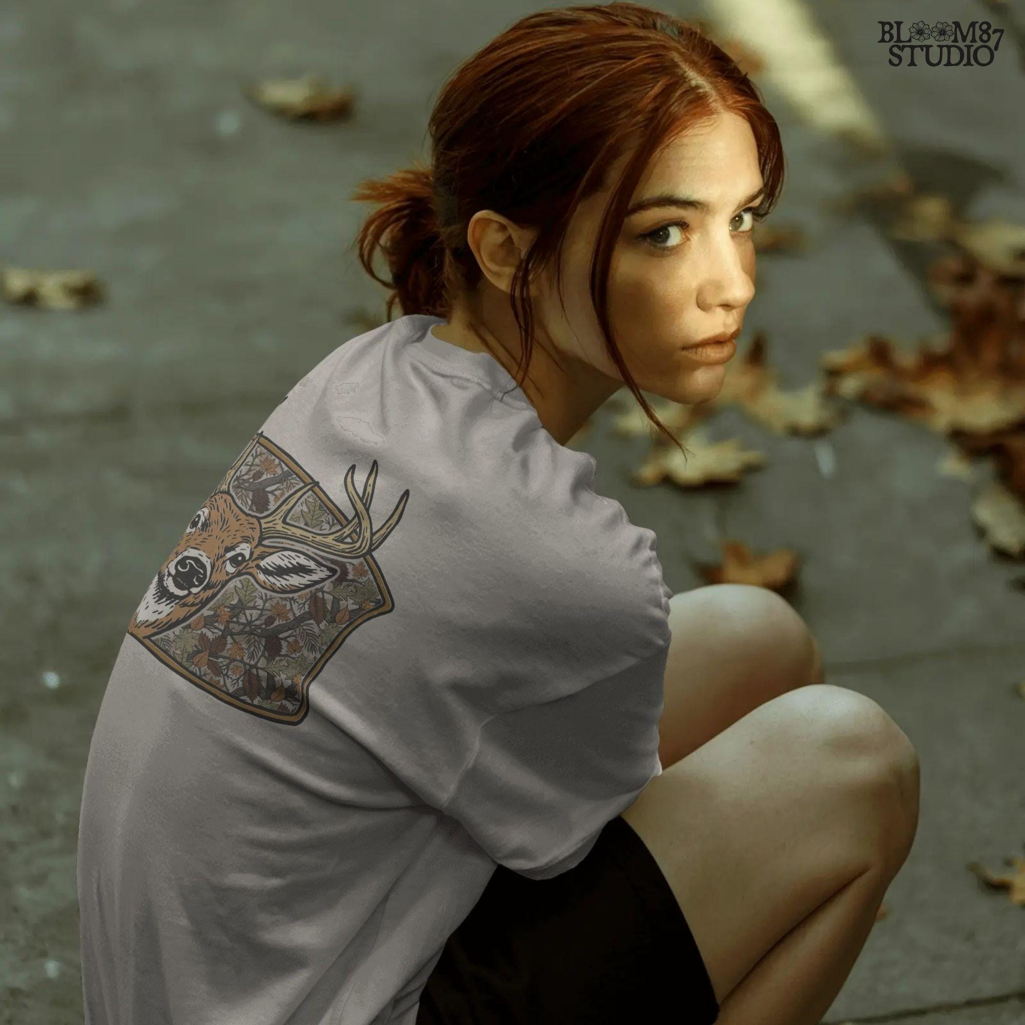 Illustration of a whitetail buck with large antlers in front of a fall forest camo background featuring leaves and branches, perfect for hunting-themed sublimation.