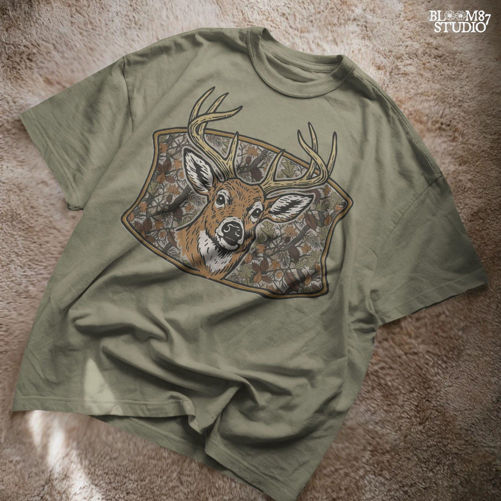 Illustration of a whitetail buck with large antlers in front of a fall forest camo background featuring leaves and branches, perfect for hunting-themed sublimation.