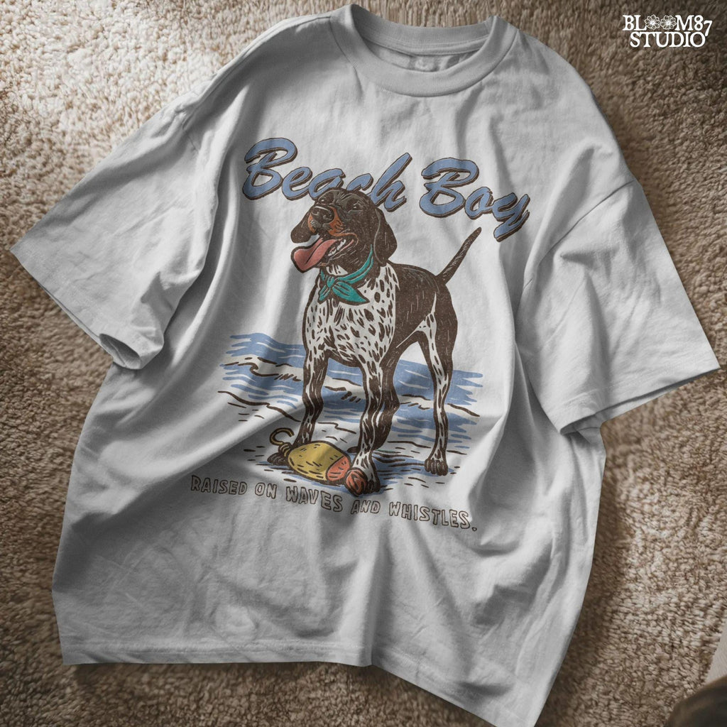 Vintage-style German Shorthaired Pointer standing on the beach with a buoy toy, text reads “Beach Boy – Raised on Waves and Whistles” – summer dog PNG.