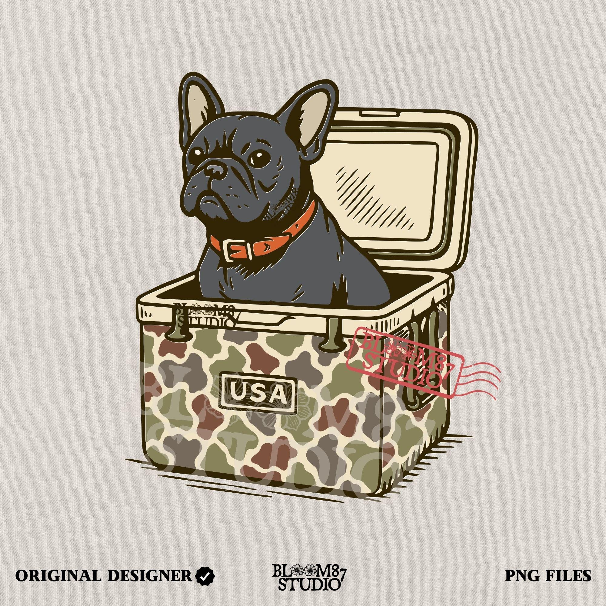 French Bulldog sitting inside a camouflage USA cooler, wearing a red collar, in rustic outdoor style — perfect for patriotic dog lovers and sublimation use.