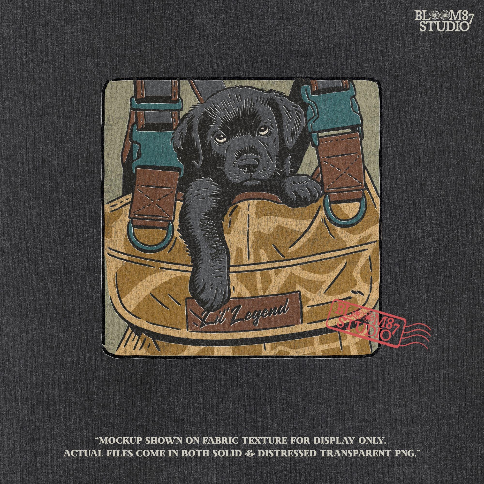 Illustration of a black Labrador puppy resting in a camouflage hunting bag with a “Lil’ Legend” tag – ideal for outdoor-themed sublimation projects.