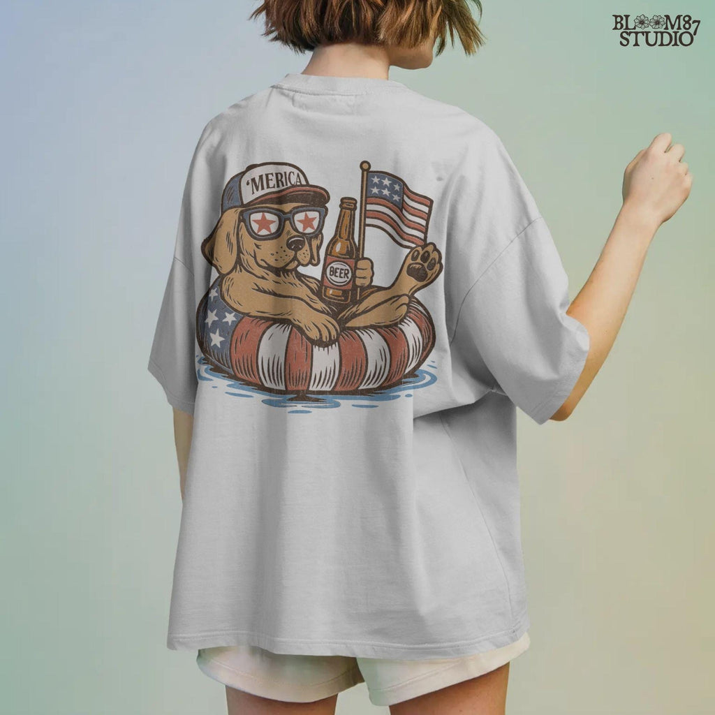 Labrador-style dog lounging on red-white-blue floaty, holding a beer and American flag, wearing patriotic hat and sunglasses – sublimation PNG for 4th of July.