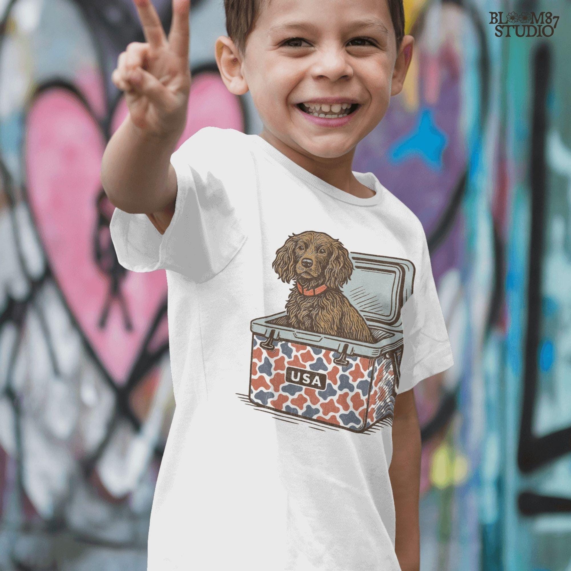 Sporting dog (spaniel type) sitting in a patriotic red-white-blue camo cooler labeled “USA” – sublimation PNG for southern dog lovers and summer crafts.