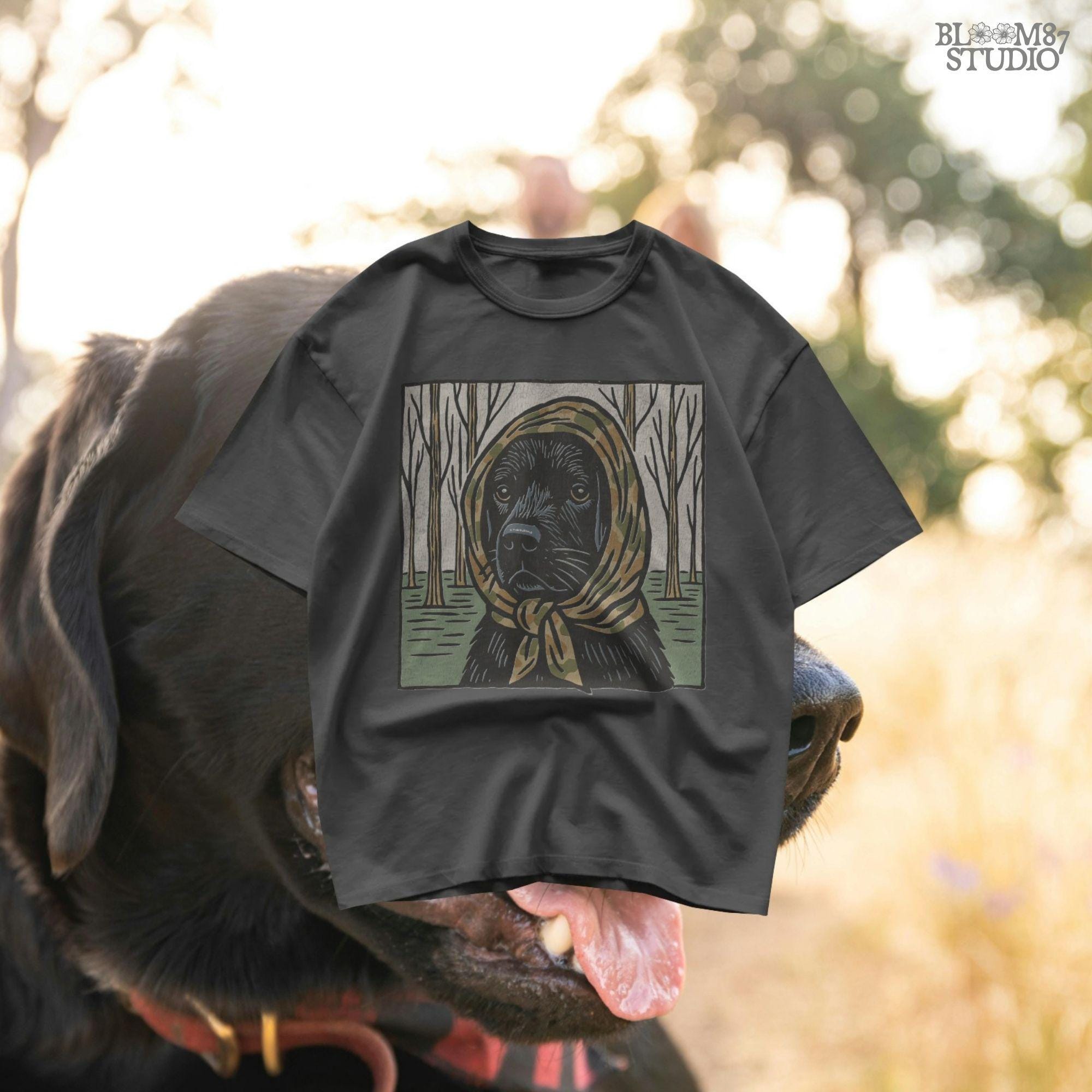 Digital PNG of a black labrador dog wearing a camo scarf in a forest setting, designed for hunting-themed sublimation printing