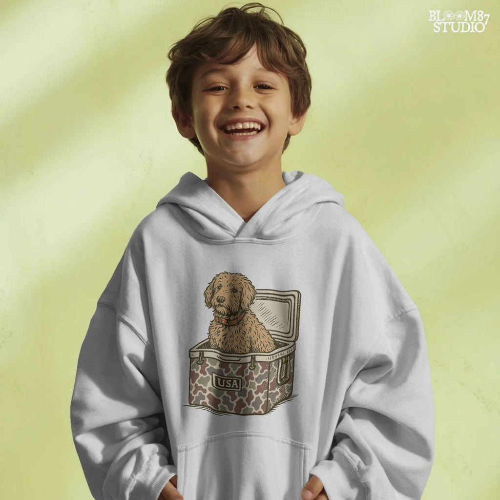 Curly Goldendoodle dog sitting inside a USA camouflage cooler, digital PNG sublimation file for crafting patriotic pet-themed items.