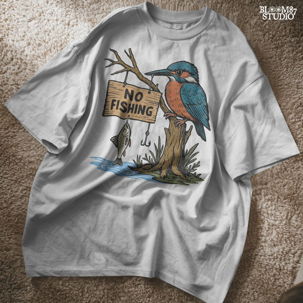 Cartoon kingfisher bird sitting on a tree holding a “No Fishing” sign with a fish hanging below, in a humorous lake life design