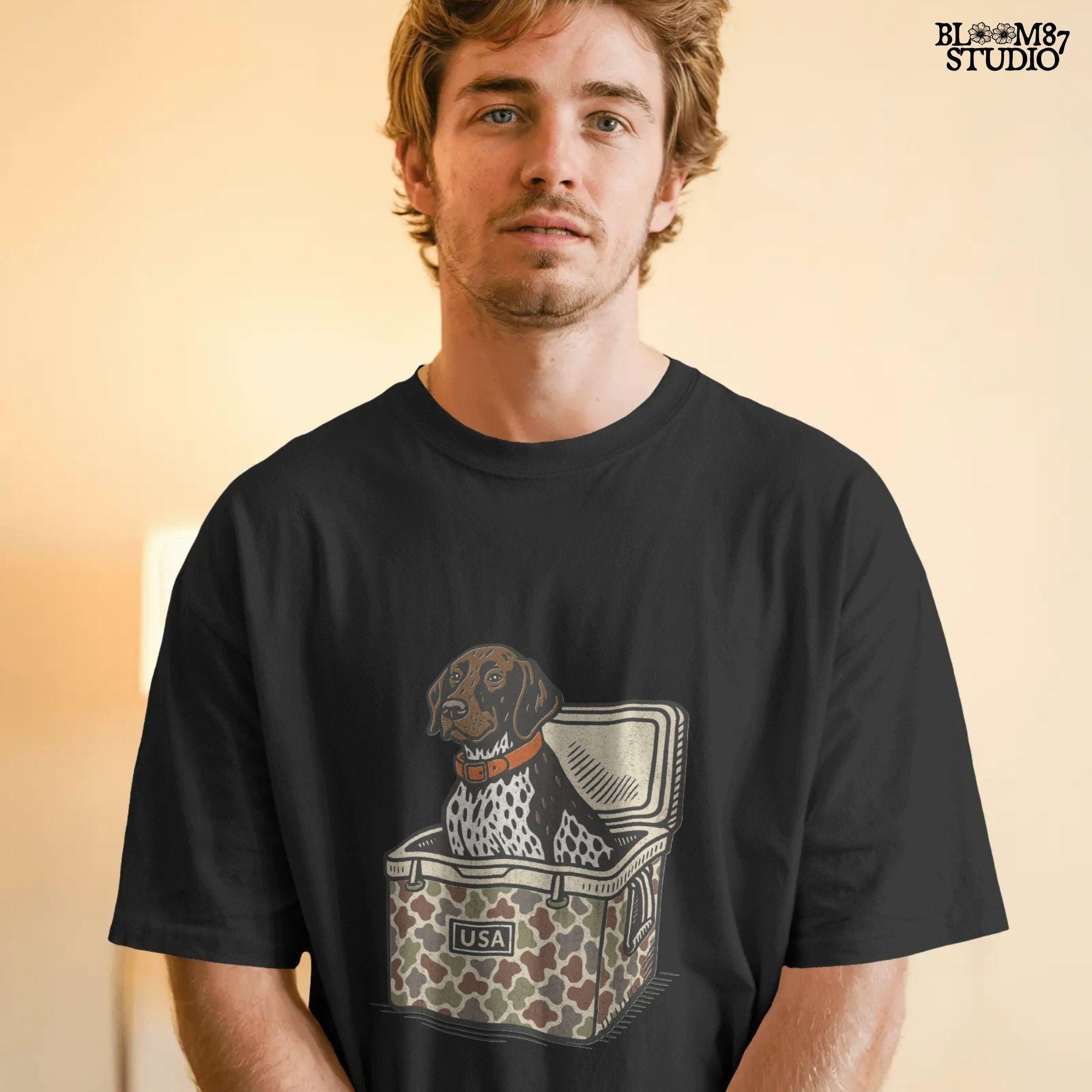 German Shorthaired Pointer dog sitting inside camouflage cooler labeled “USA,” in rustic cartoon patriotic style