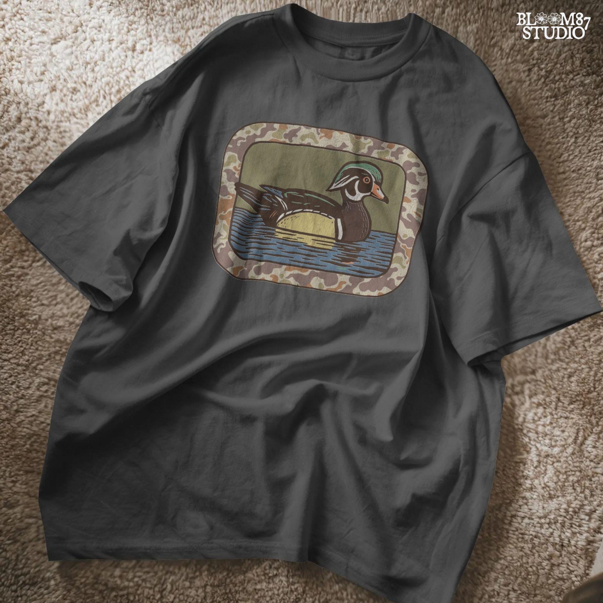 Rustic wood duck illustration with green, brown, and tan camo border; sublimation PNG for hunting or wildlife-themed crafts and apparel.