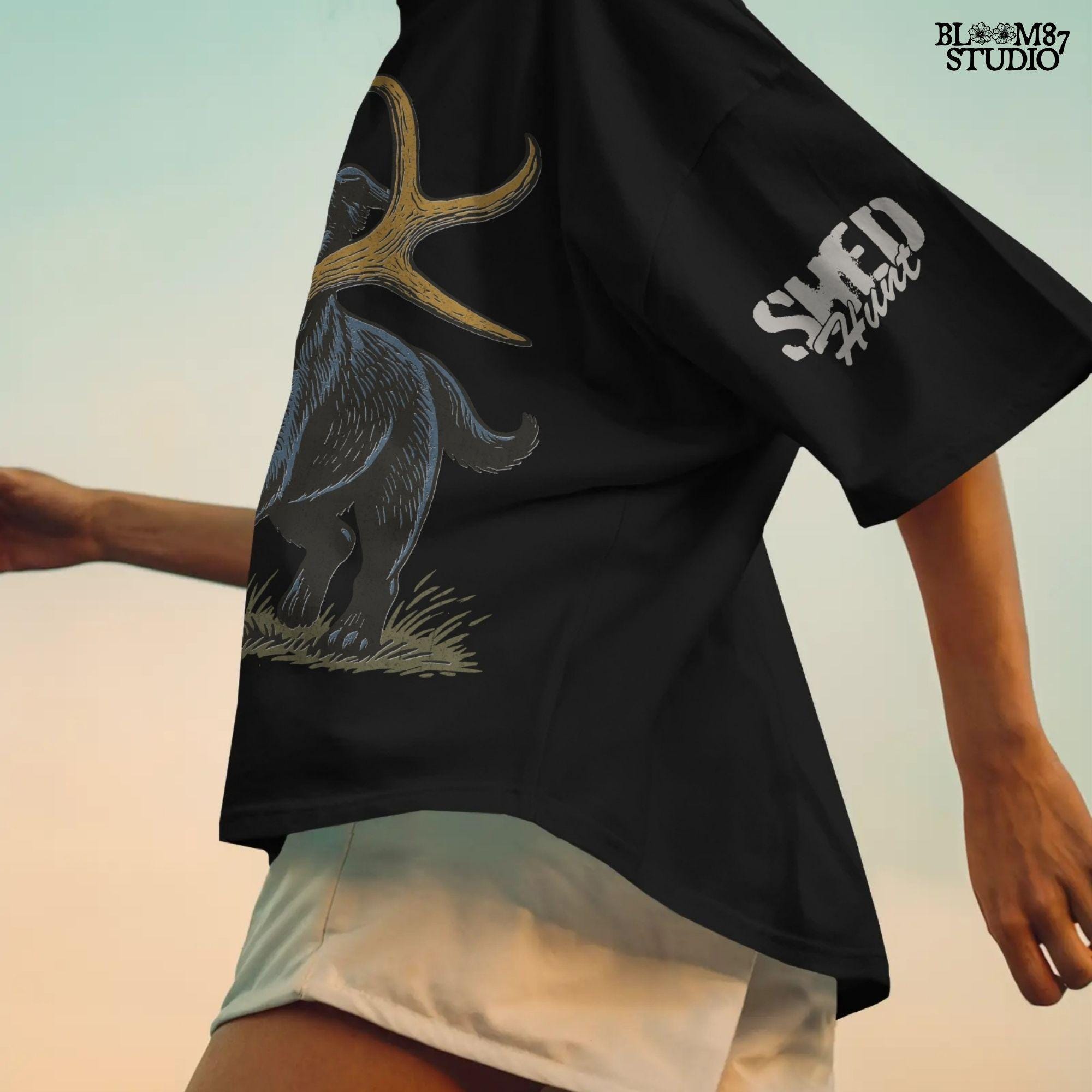 Black Labrador retriever running with a deer shed antler in its mouth, with bonus “Shed Hunt” circular pocket badge in rustic style