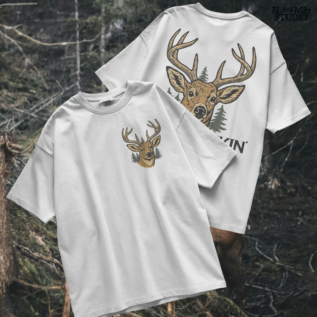 Rustic illustration of a buck deer with antlers and pine trees, text below says “Best Buckin’ Dad Ever” in bold and script font