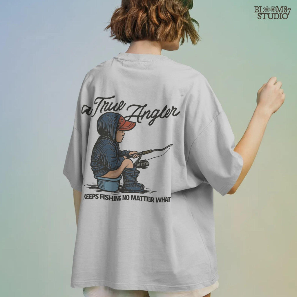 Cartoon of young boy sitting on a bucket in hoodie and boots, fishing with full focus, with the quote “A True Angler Keeps Fishing No Matter What.”