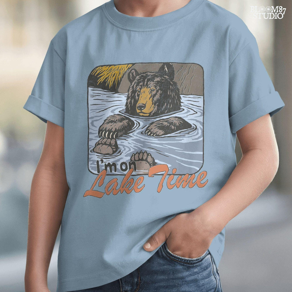 Cartoon bear relaxing in a lake with paws up, text reads “I’m on Lake Time,” in a cozy, vintage outdoor style.