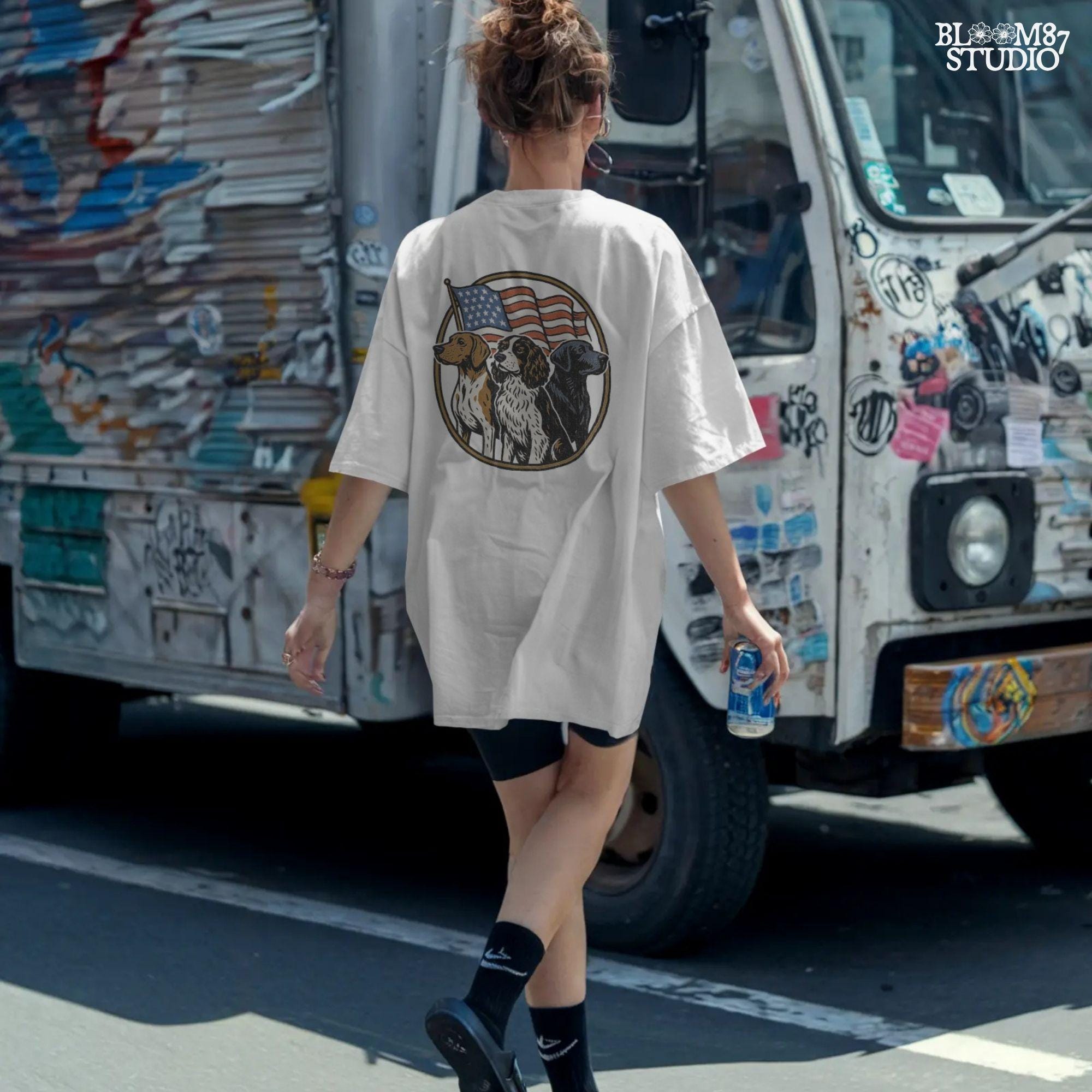 Illustration of three hunting dogs — Labrador, Spaniel, and Beagle — standing in front of a waving American flag, designed for patriotic dog lover sublimation projects.