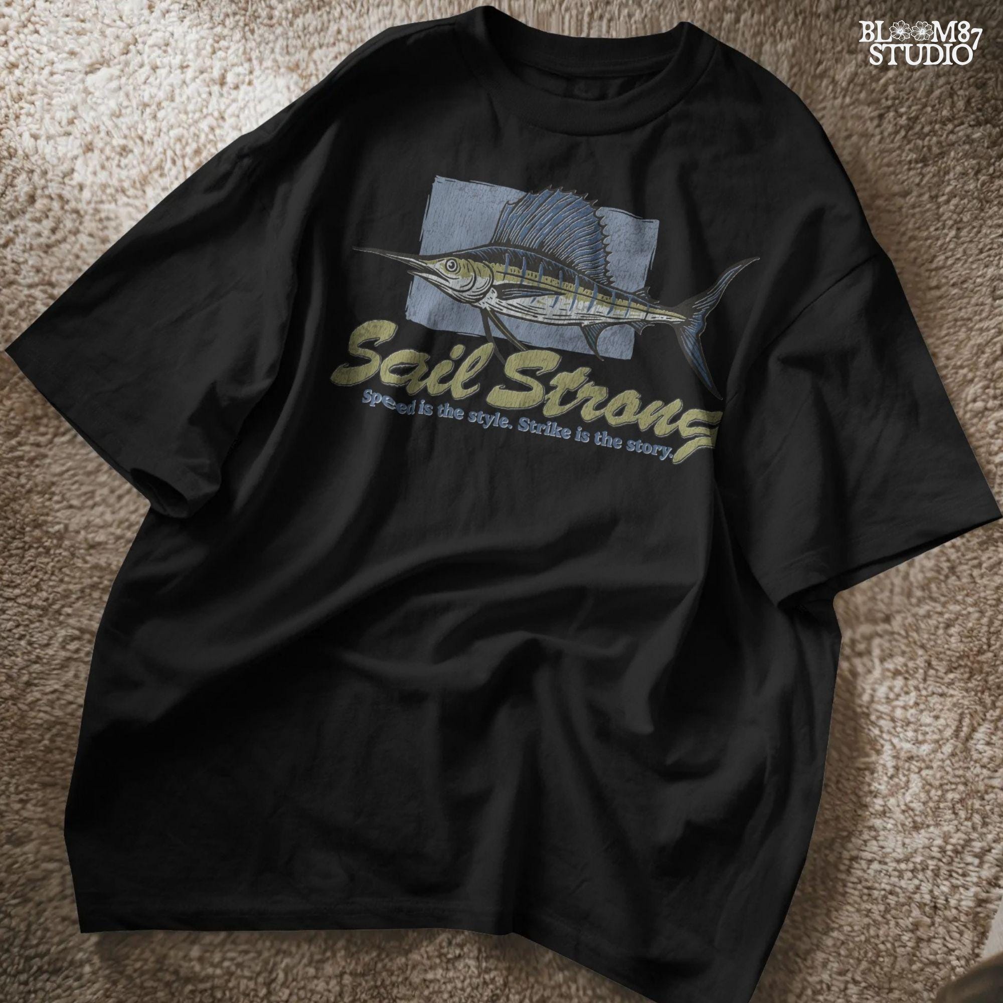 Illustrated sailfish with bold dorsal fin and text “Sail Strong – Speed is the style. Strike is the story” in nautical, vintage style.