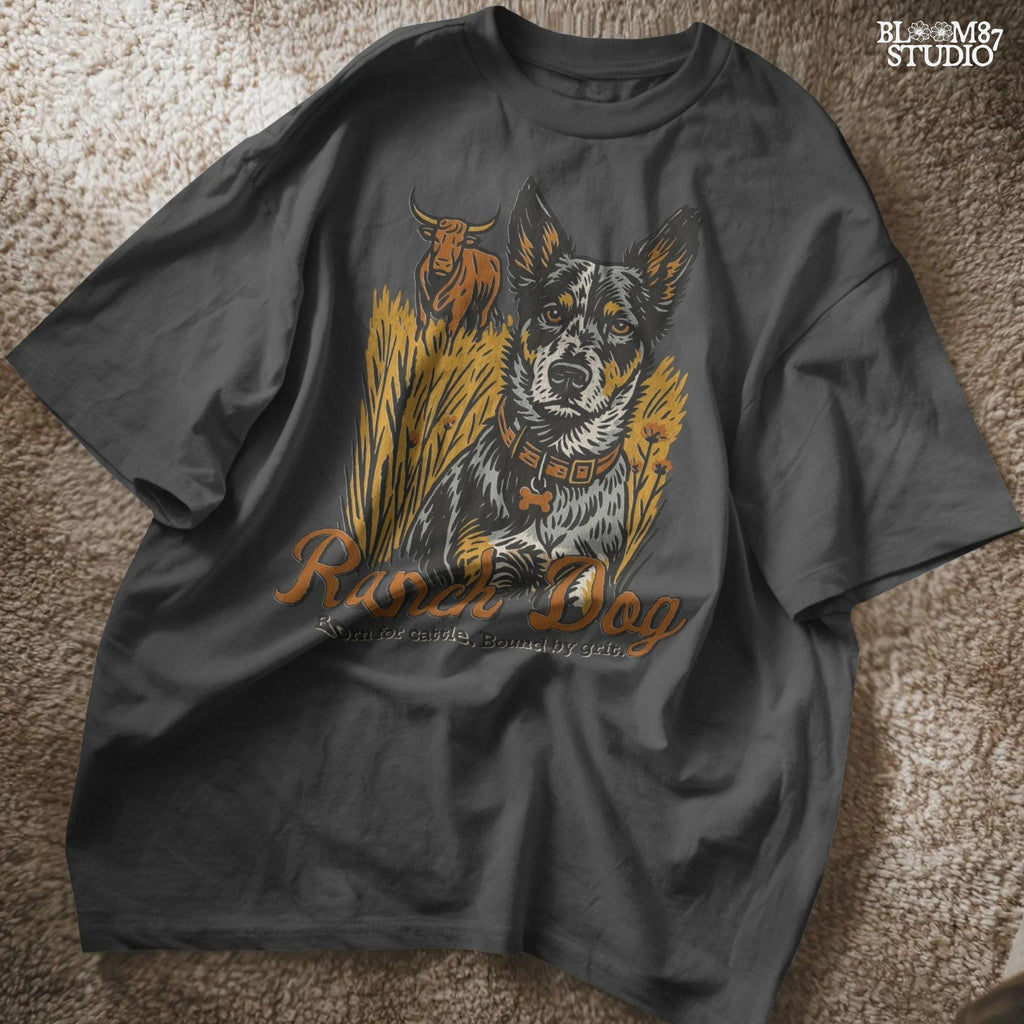 Vintage-style illustration of an Australian cattle dog sitting in a field with a longhorn cow behind, and the phrase “Ranch Dog – Born for cattle. Bound by grit.”