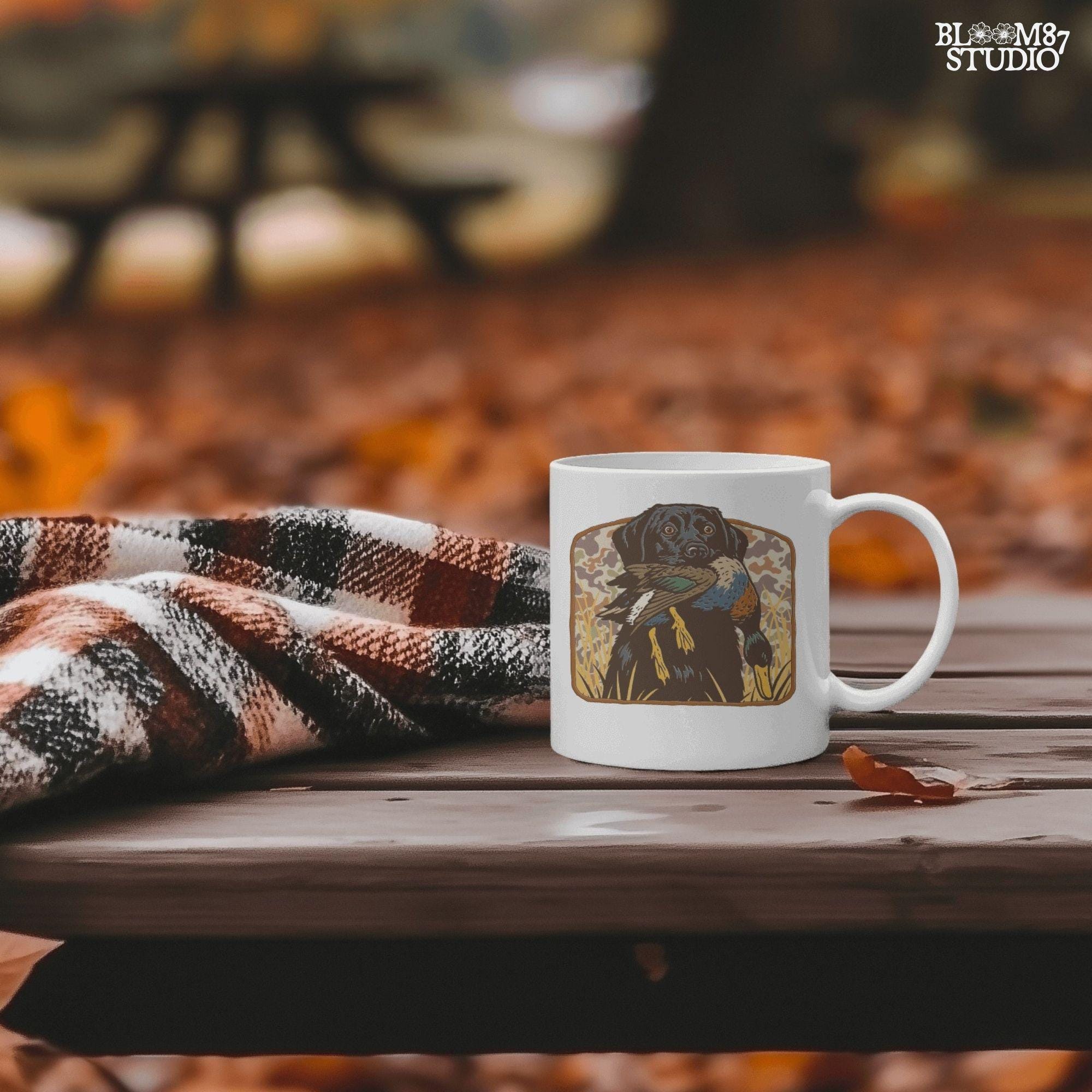 Vintage-style illustration of a black Labrador retriever holding a mallard duck in its mouth with a camouflage background, ideal for duck hunting designs.