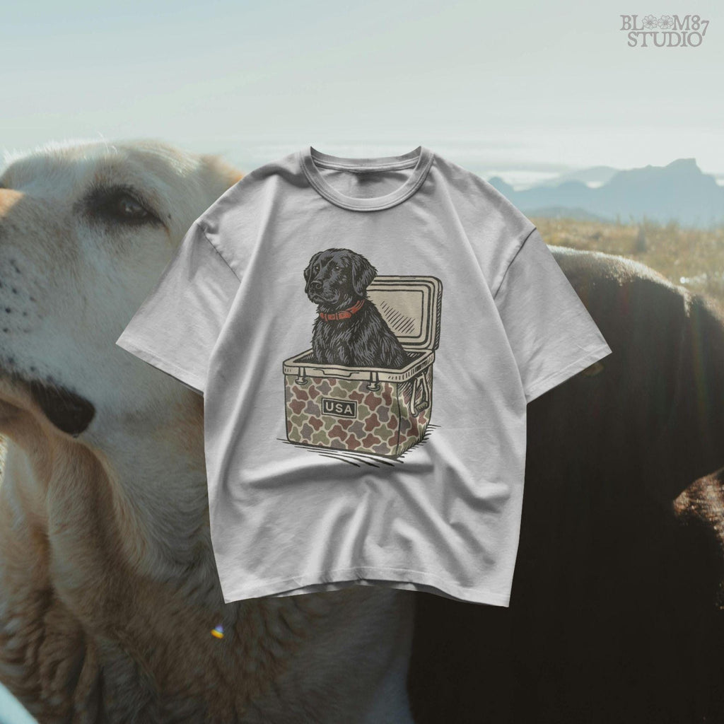 Hand-drawn black Labrador retriever sitting in a camouflage cooler labeled “USA,” designed for sublimation and hunting-themed merchandise.