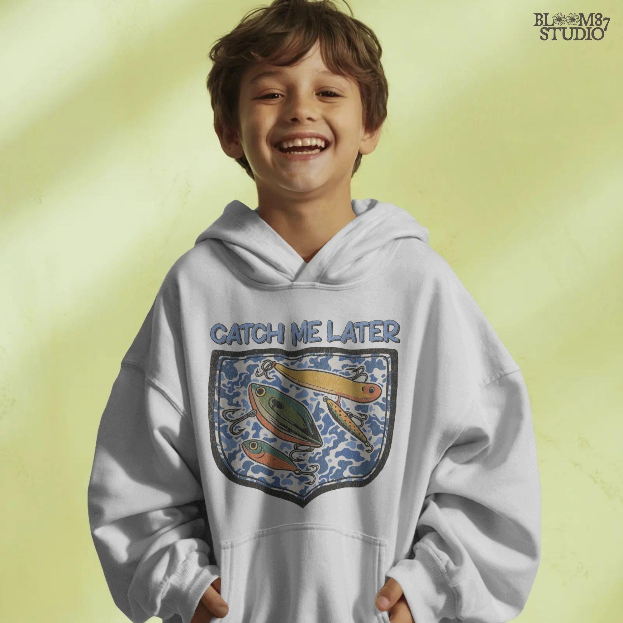 Funny “Catch Me Later” text above a faux blue camo pocket with colorful fishing lures, designed for sublimation printing on fisherman-themed apparel.