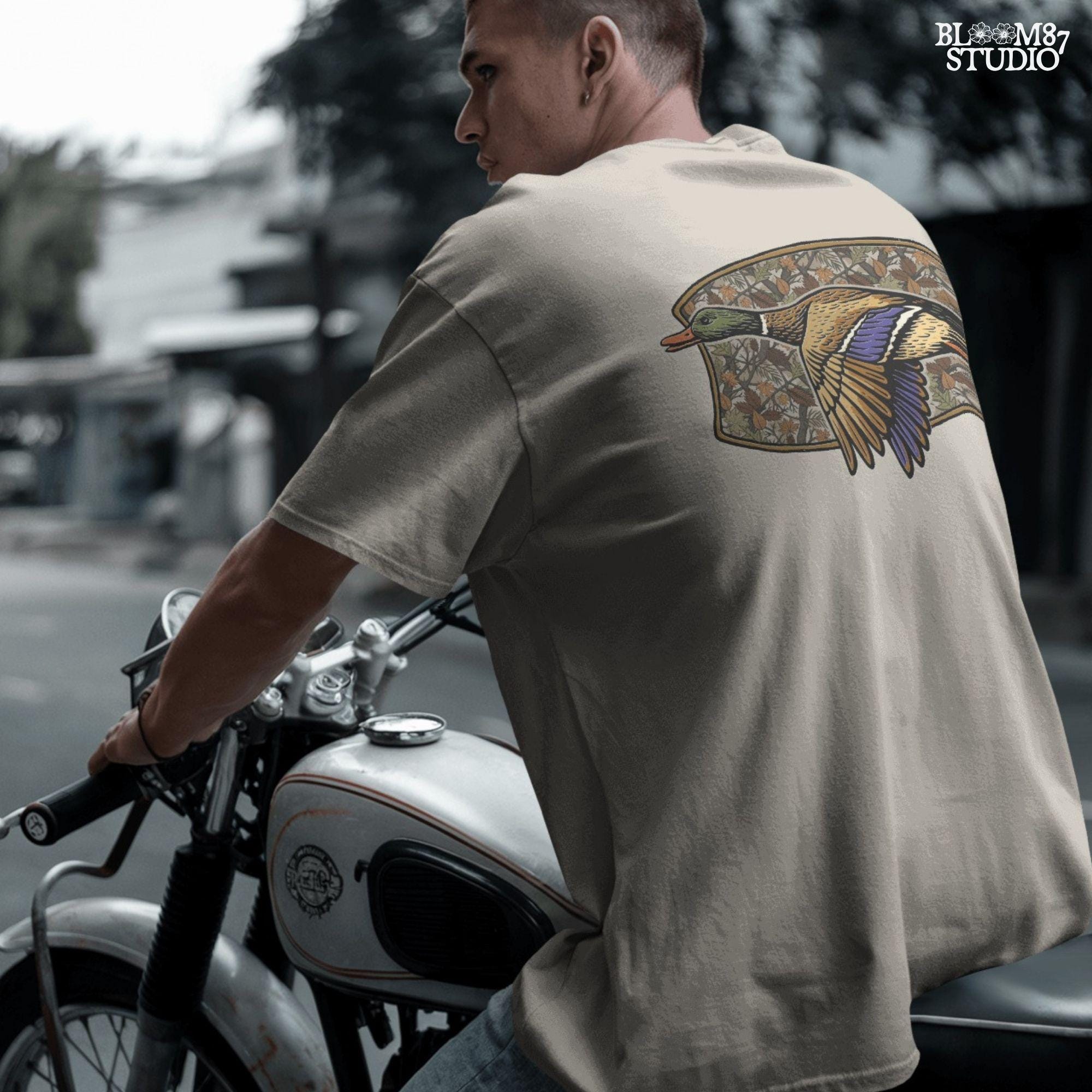 Illustration of a flying mallard duck over a fall camouflage background with oak and maple leaves, designed for hunting-themed sublimation and outdoor shirts.