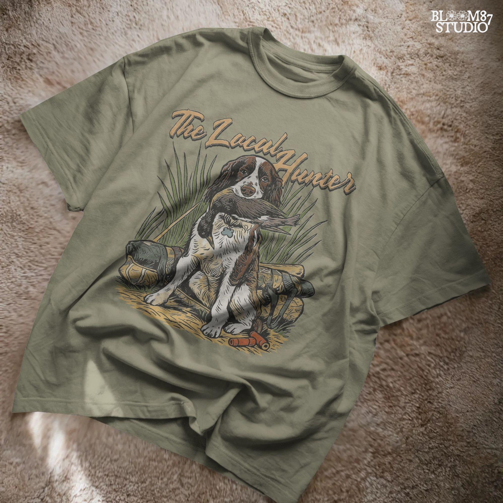 Vintage illustration of a Springer Spaniel hunting dog holding a duck in its mouth with grass, ammo, and hunting gear around, and the phrase “The Local Hunter” above.