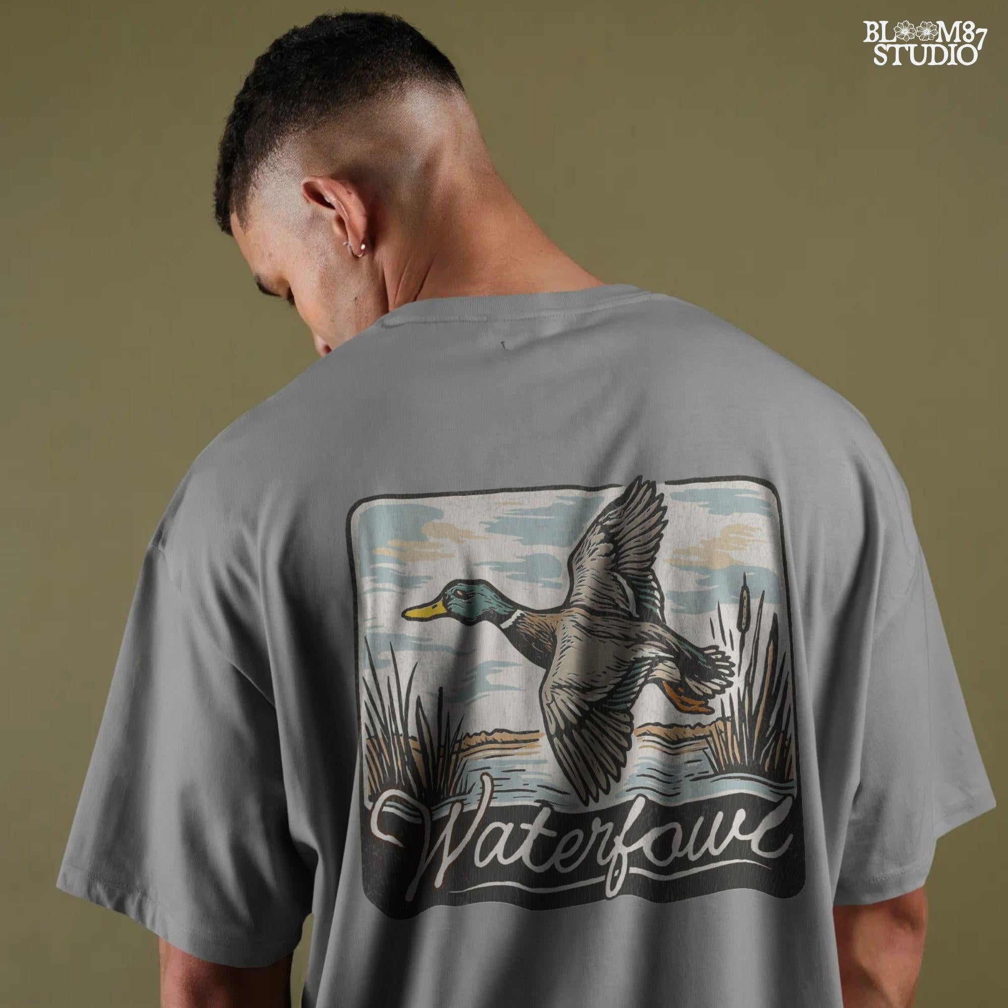 Vintage-style illustration of a flying mallard duck over a marsh with the word “Waterfowl” in script, perfect for duck hunting and outdoor-themed designs.