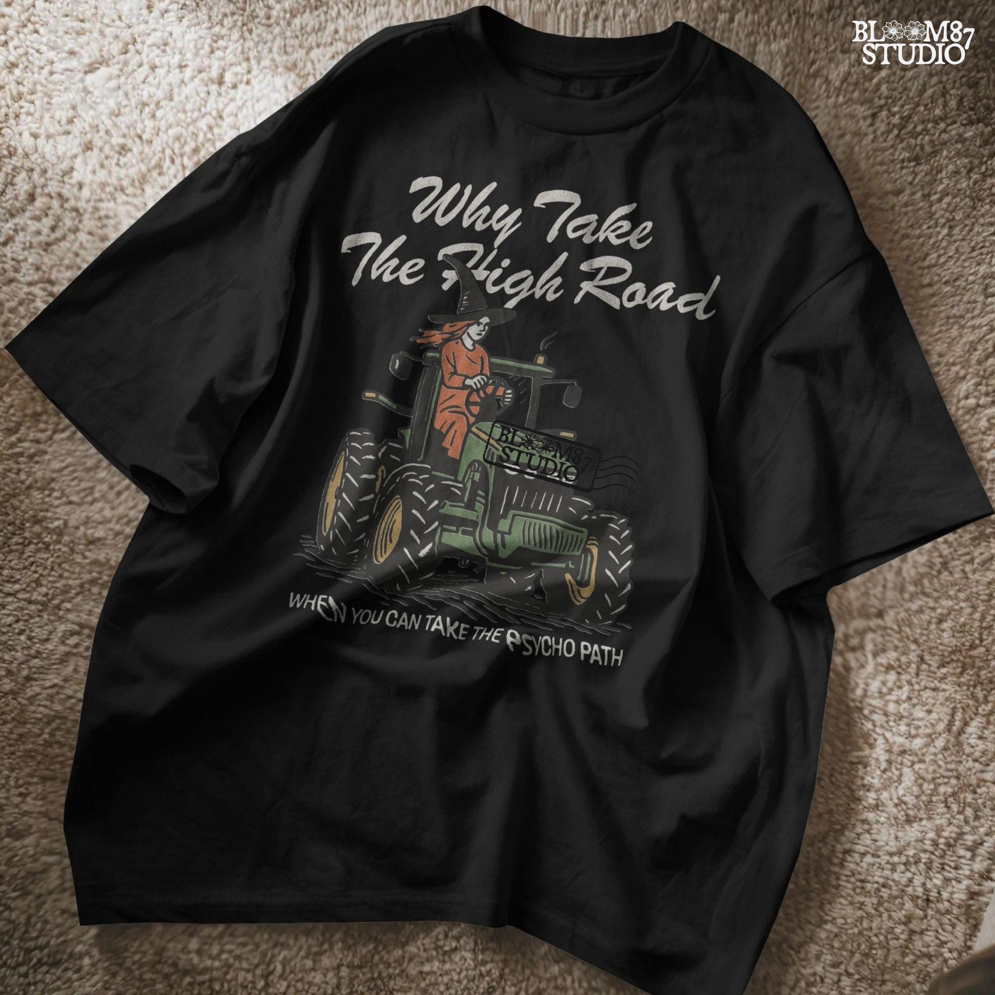 Funny illustration of a red-haired witch in a black hat driving a green tractor with the quote “Why take the high road when you can take the psycho path,” in rustic cartoon style.