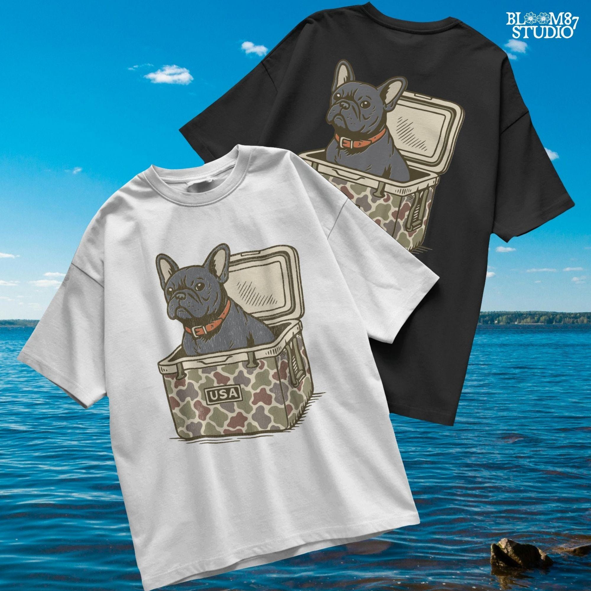 French Bulldog sitting inside a camouflage USA cooler, wearing a red collar, in rustic outdoor style — perfect for patriotic dog lovers and sublimation use.