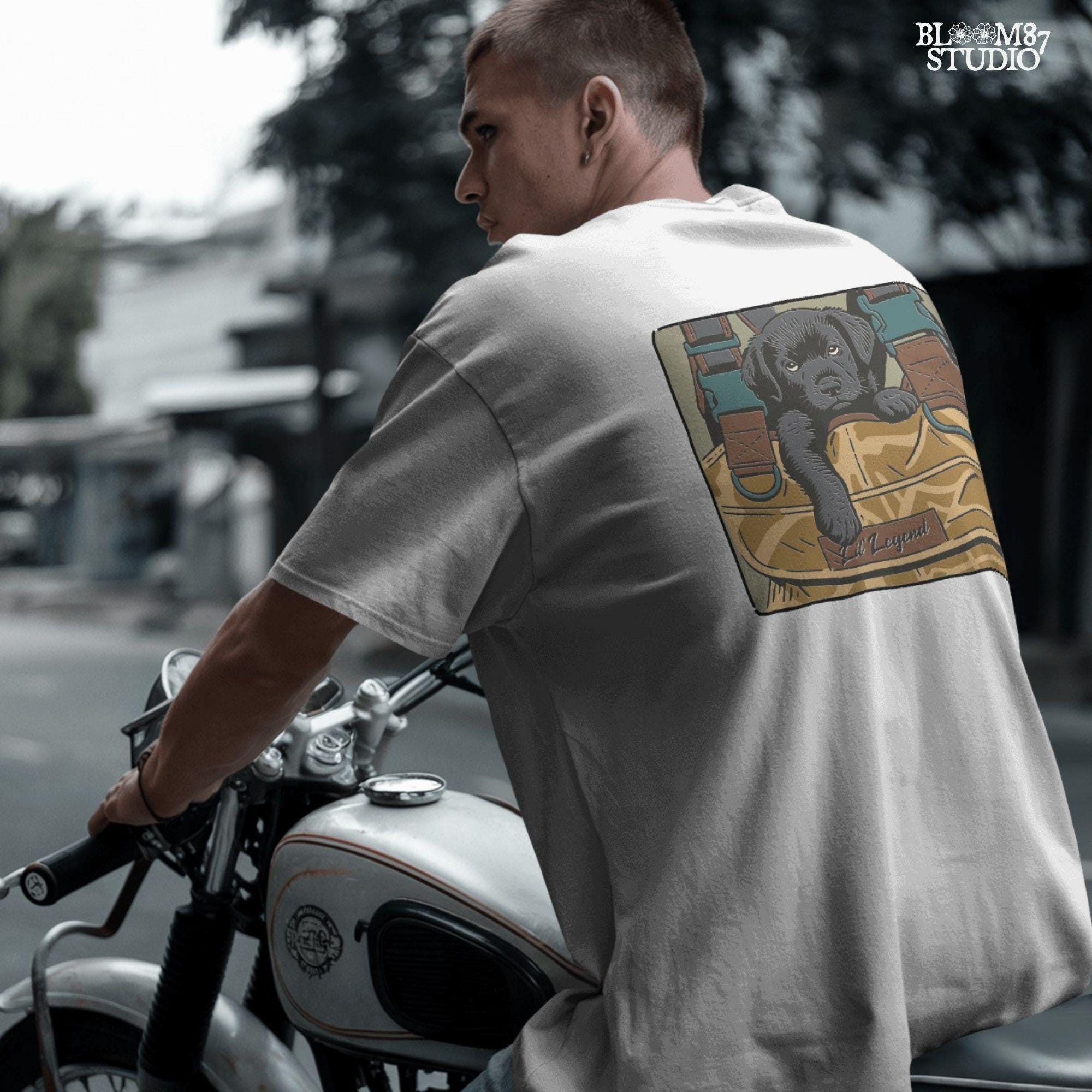 Illustration of a black Labrador puppy resting in a camouflage hunting bag with a “Lil’ Legend” tag – ideal for outdoor-themed sublimation projects.