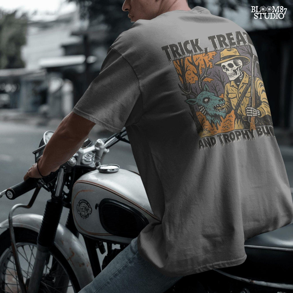 Vintage-style Halloween illustration of a skeleton hunter holding a severed zombie deer head with the phrase “Trick, Treat and Trophy Bucks,” in spooky forest setting.