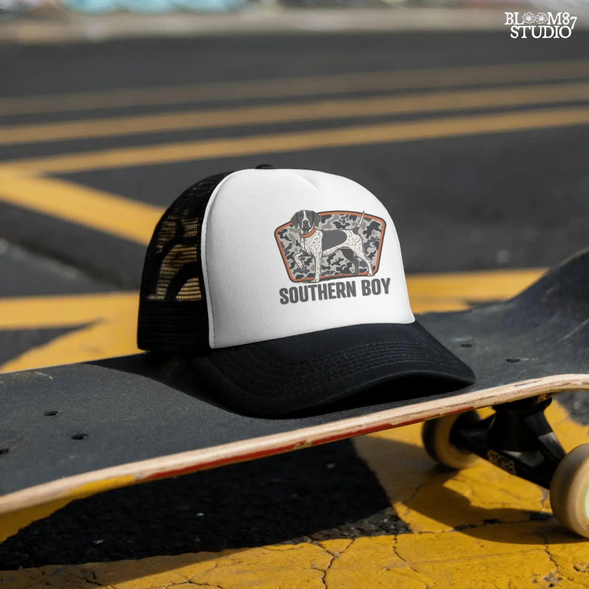 Illustration of a black and white pointer hunting dog standing in front of a gray camo background with the words “Southern Boy” beneath in bold rustic font.