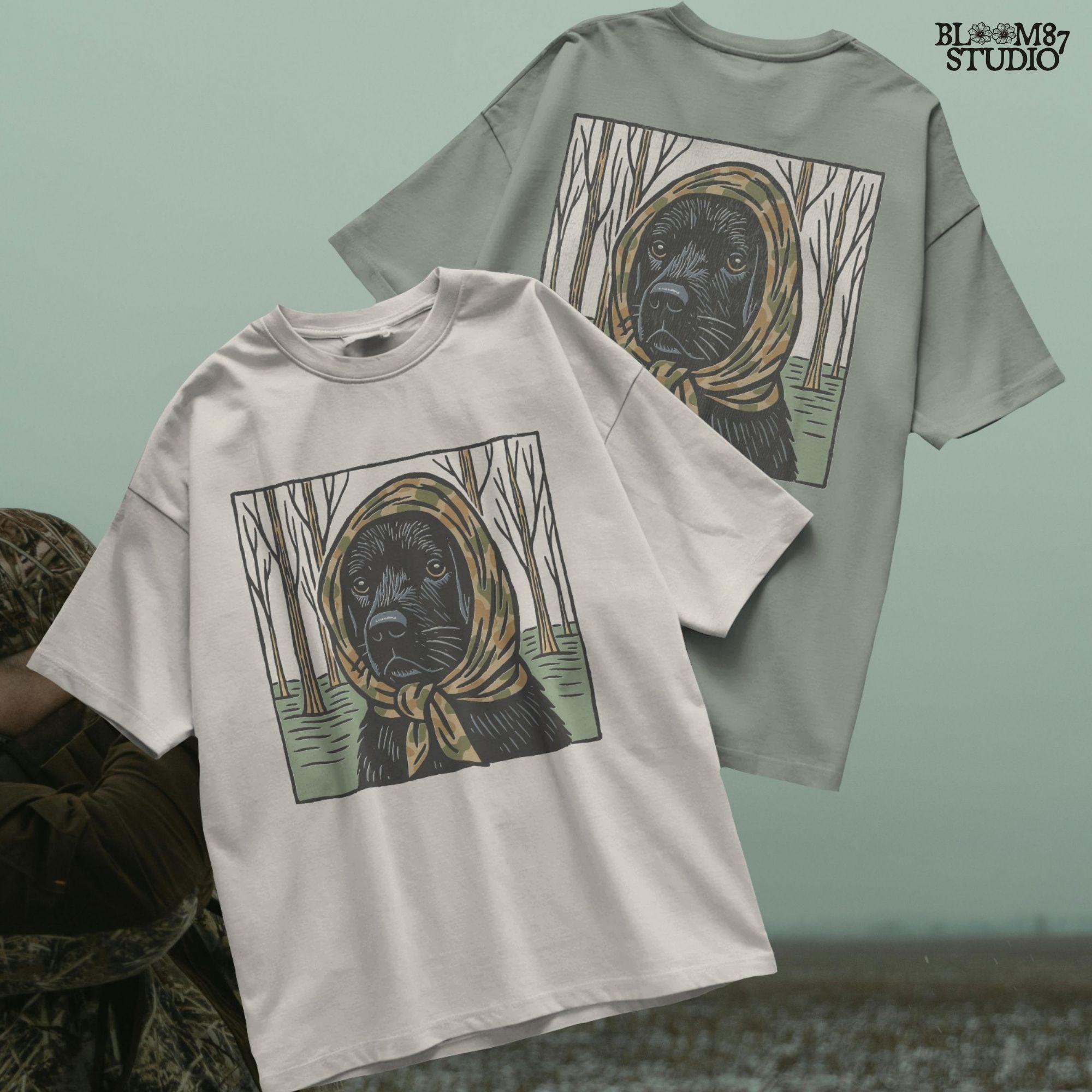 Digital PNG of a black labrador dog wearing a camo scarf in a forest setting, designed for hunting-themed sublimation printing