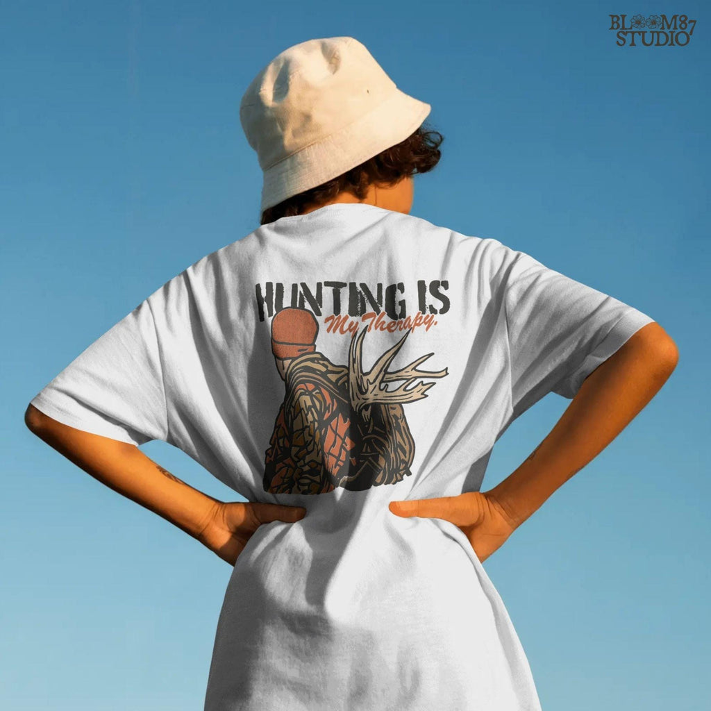 A camouflage hunter with antlers on backpack and text “Hunting Is My Therapy,” designed for fall hunting season sublimation and outdoor-themed apparel.