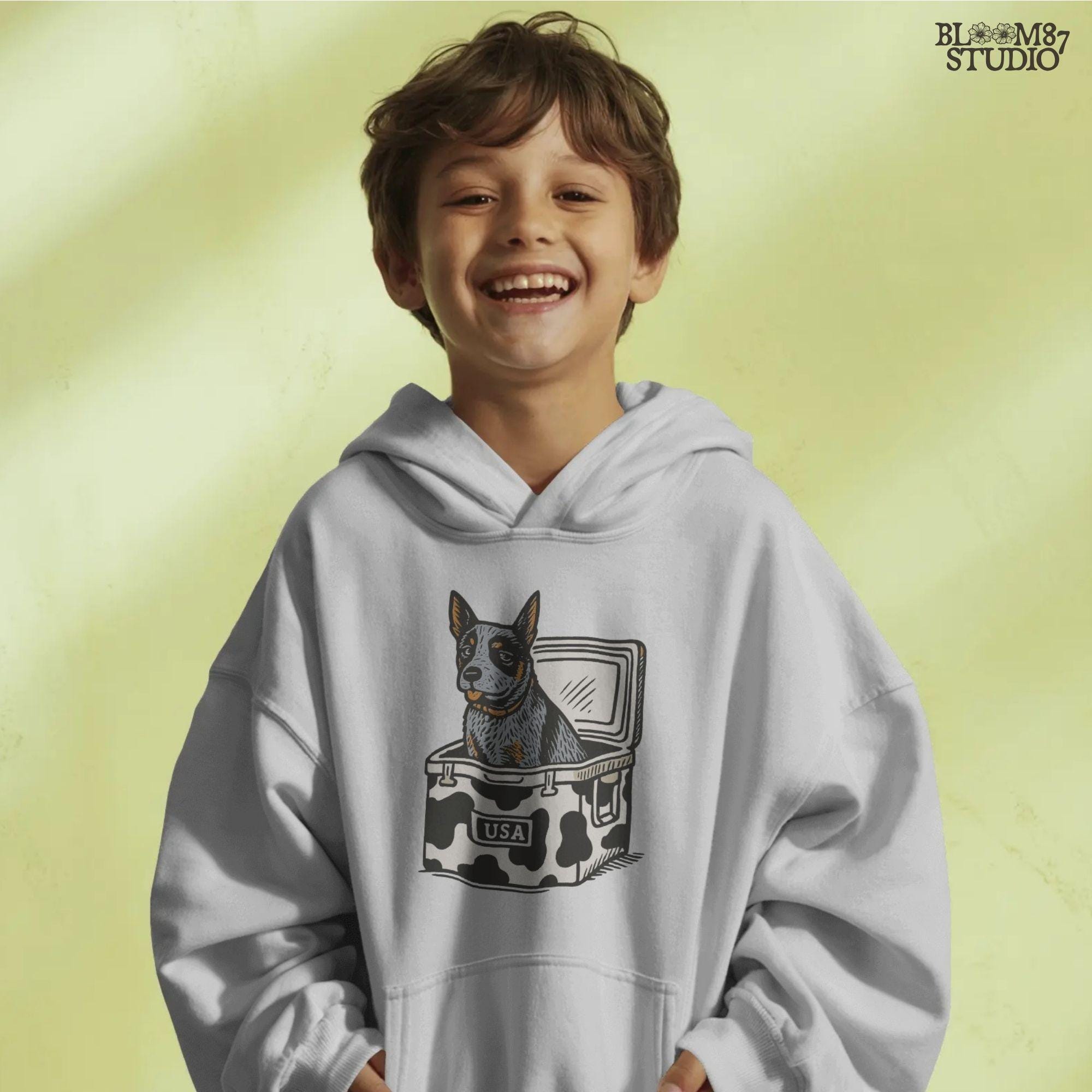 Cartoon-style Blue Heeler dog sitting inside a cowprint cooler with USA patch, perfect for southern patriotic summer sublimation design.