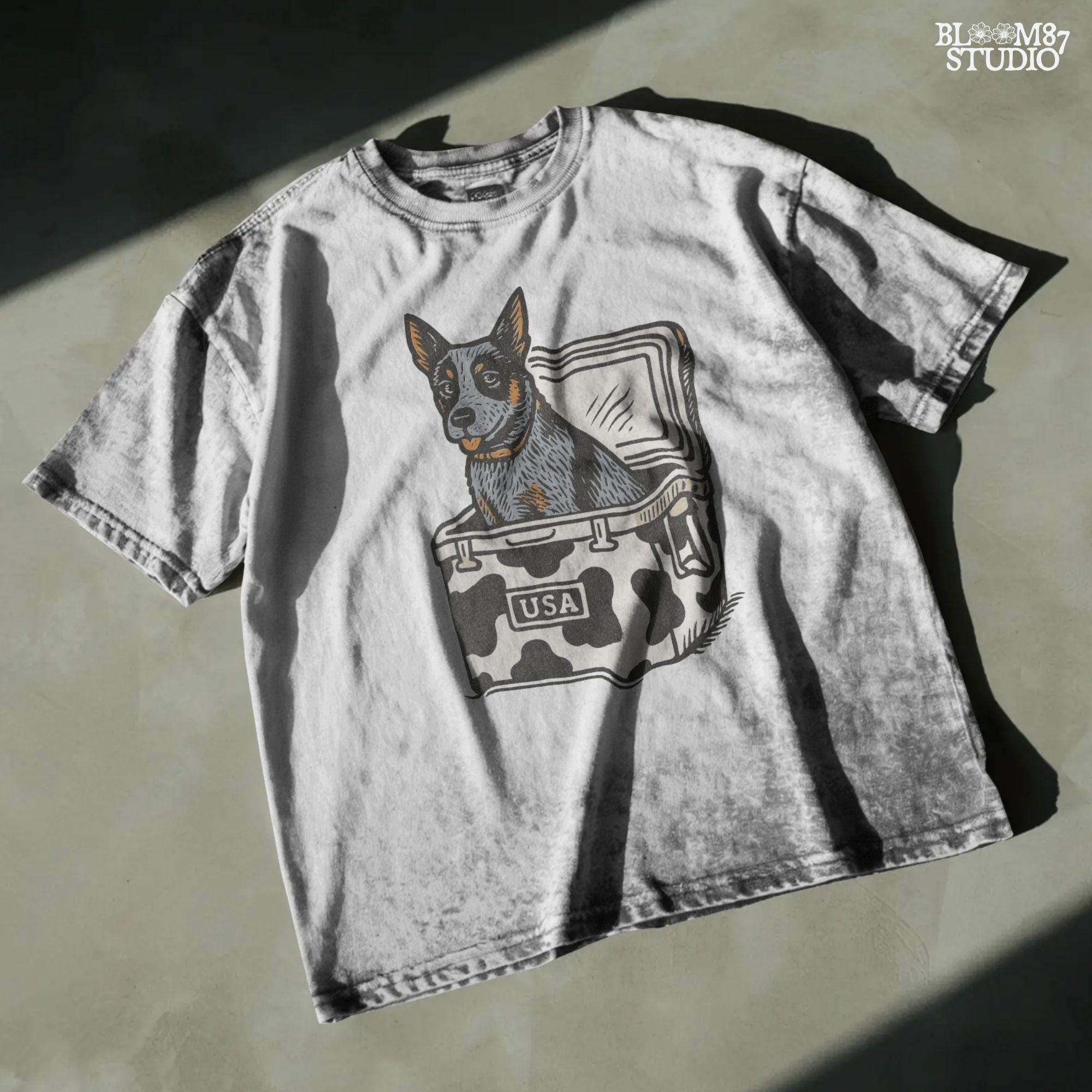 Cartoon-style Blue Heeler dog sitting inside a cowprint cooler with USA patch, perfect for southern patriotic summer sublimation design.