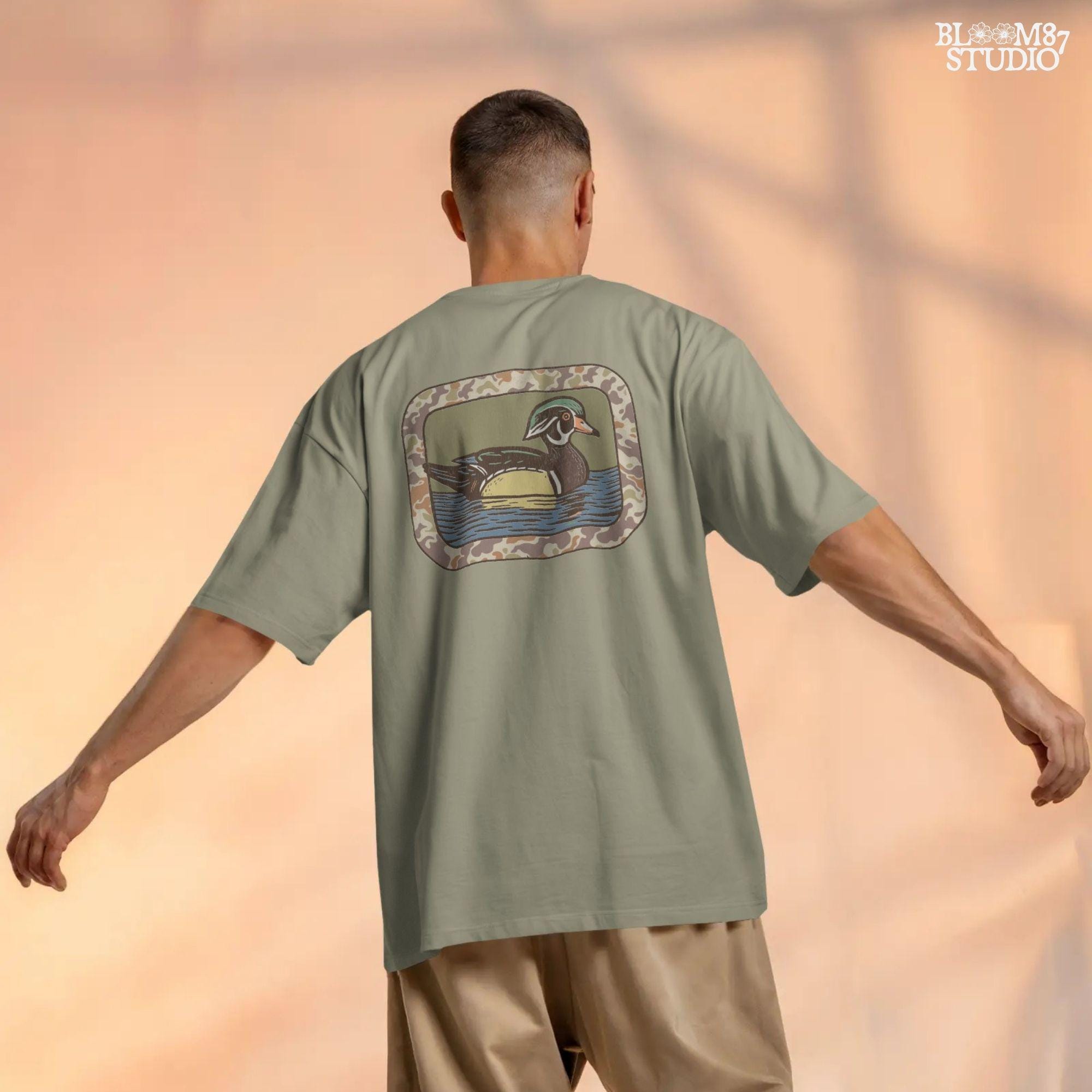 Rustic wood duck illustration with green, brown, and tan camo border; sublimation PNG for hunting or wildlife-themed crafts and apparel.