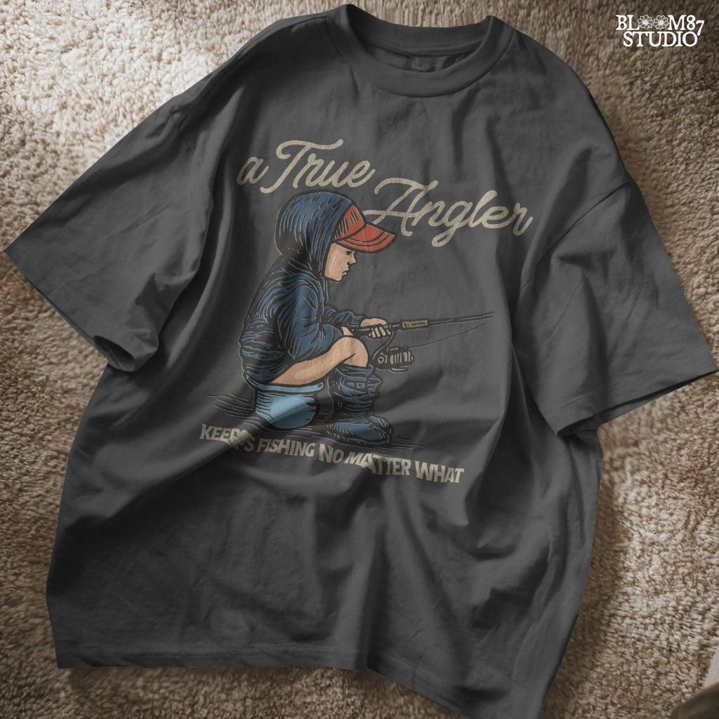 Cartoon of young boy sitting on a bucket in hoodie and boots, fishing with full focus, with the quote “A True Angler Keeps Fishing No Matter What.”