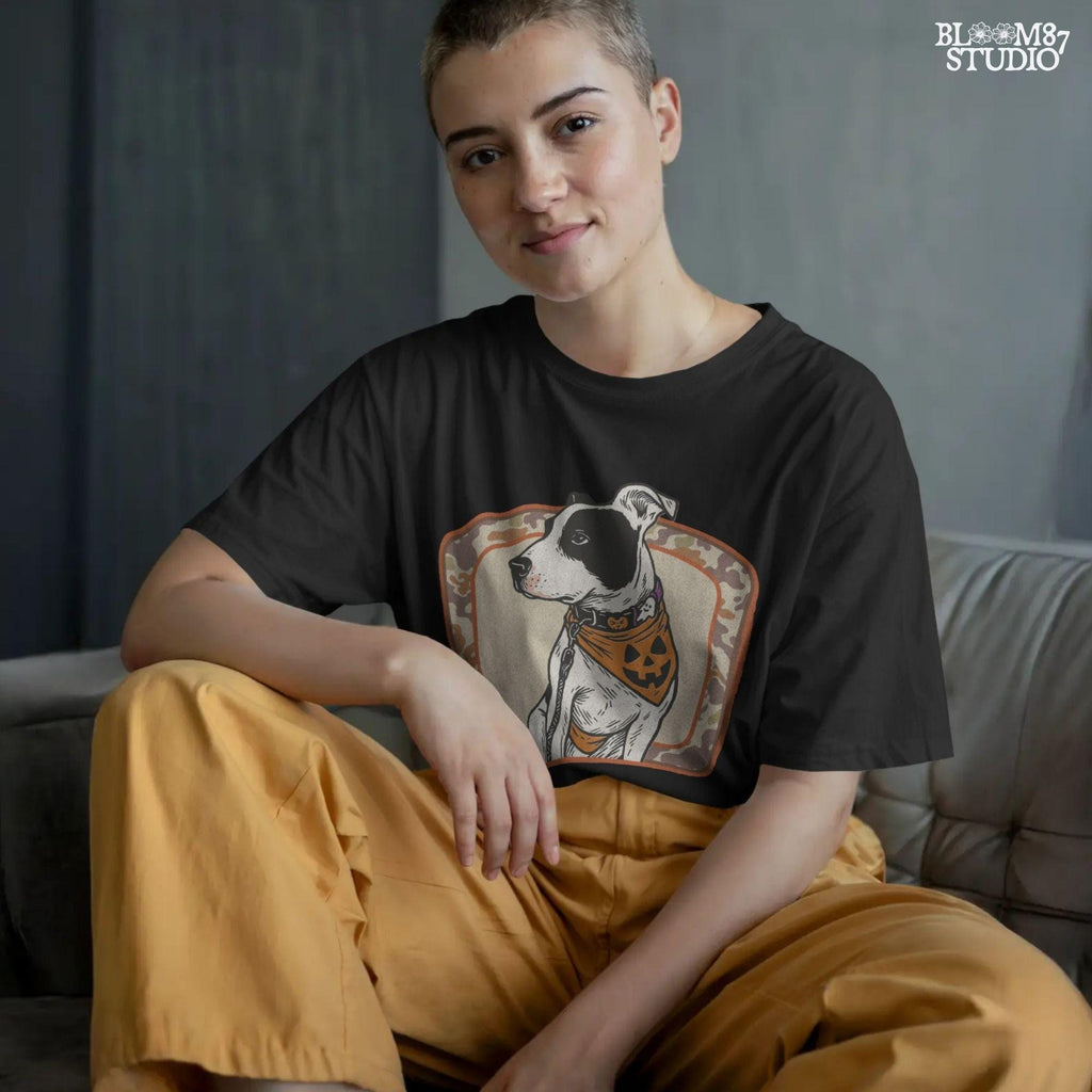 Illustration of a black and white pitbull wearing a jack-o’-lantern bandana and Halloween collar, framed by a camo background.