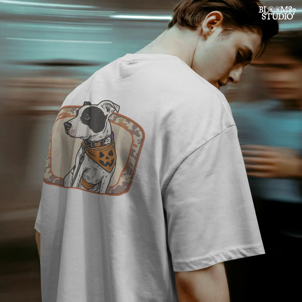 Illustration of a black and white pitbull wearing a jack-o’-lantern bandana and Halloween collar, framed by a camo background.