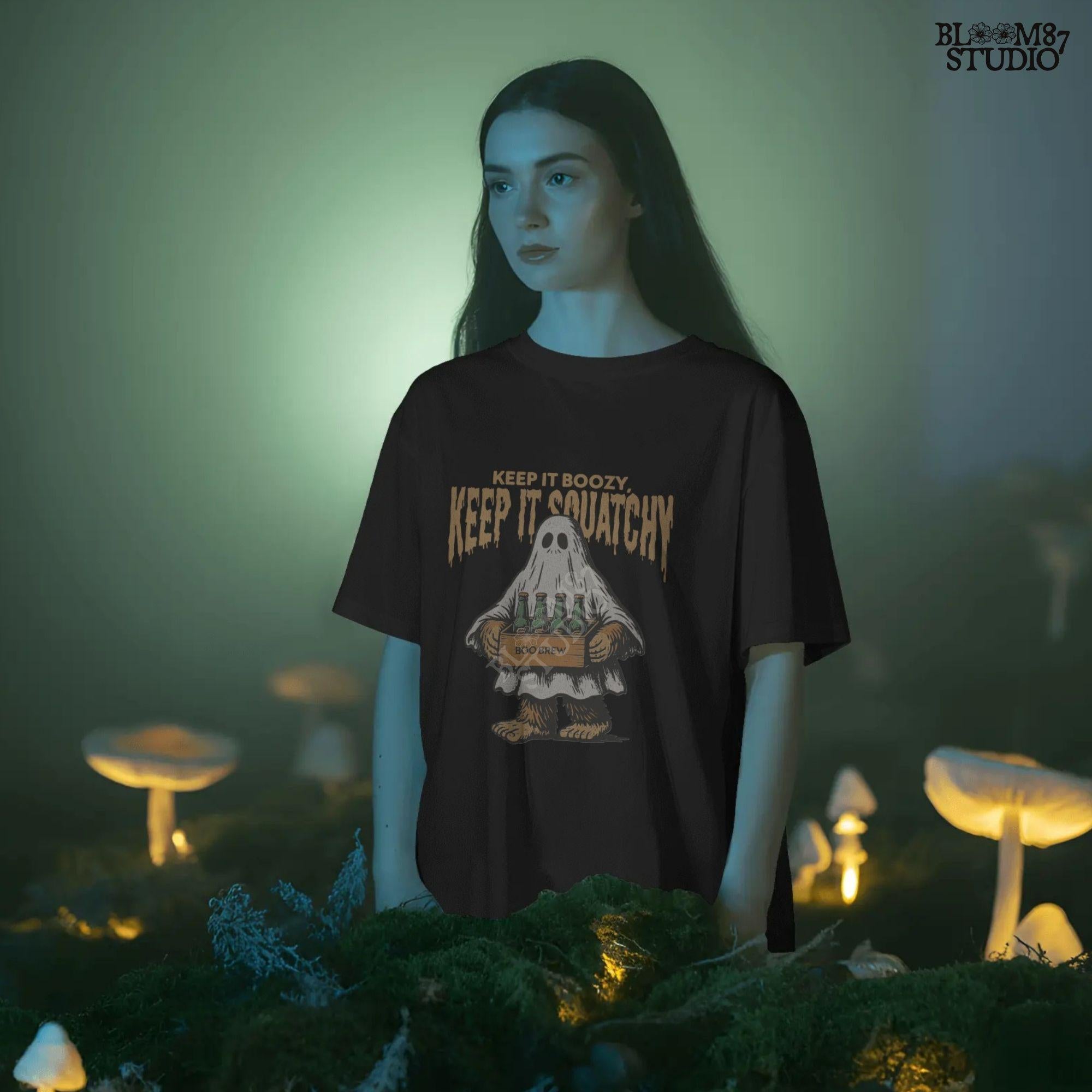 Funny Bigfoot dressed as a ghost holding a six-pack labeled “Boo Brew,” with spooky text “Keep It Boozy, Keep It Squatchy” above.