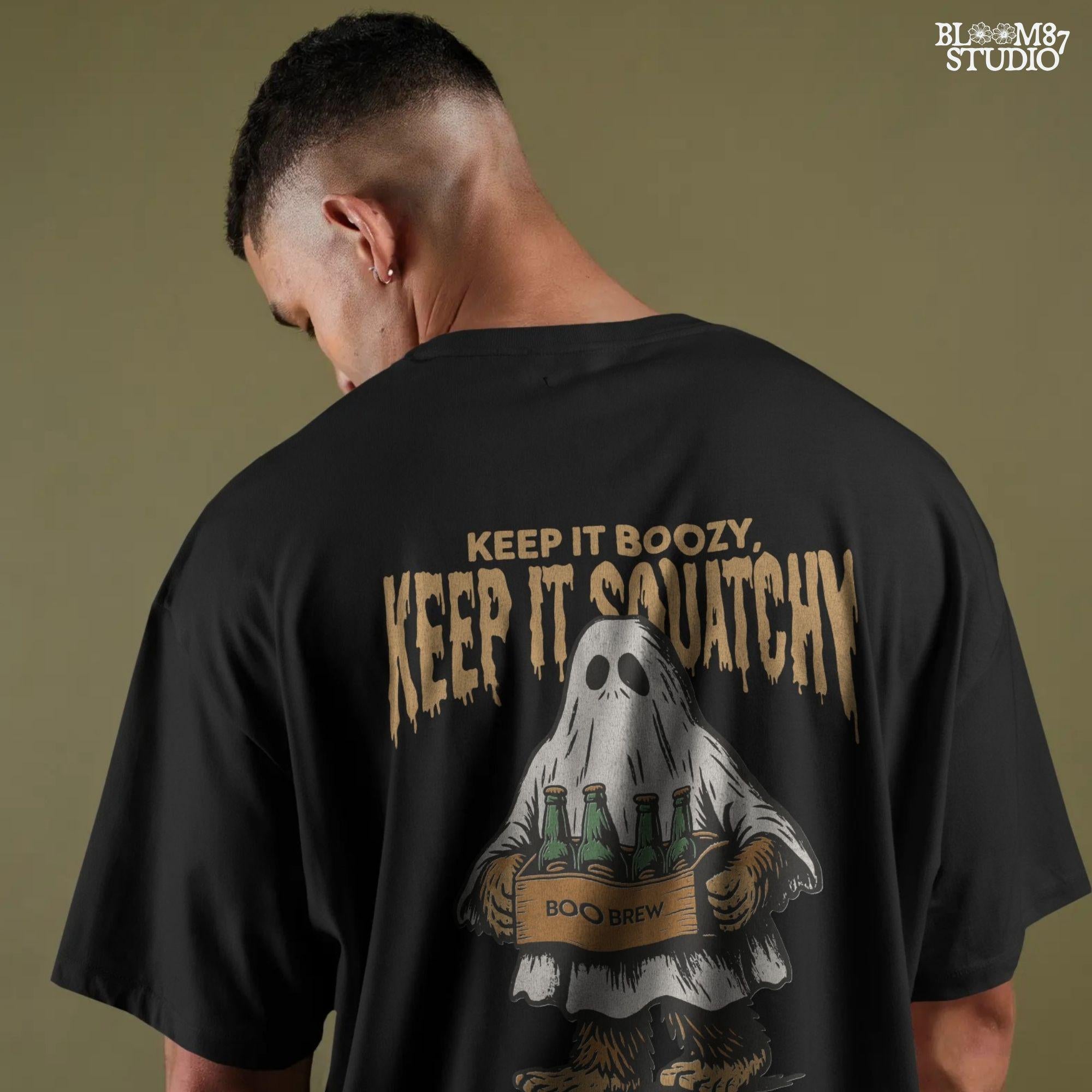Funny Bigfoot dressed as a ghost holding a six-pack labeled “Boo Brew,” with spooky text “Keep It Boozy, Keep It Squatchy” above.