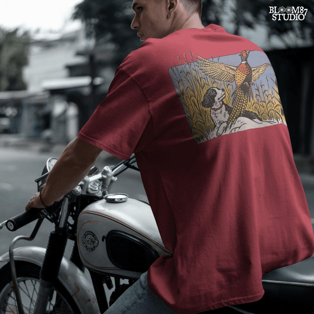 Vintage-style illustration of a black and white hunting dog watching a colorful pheasant take flight in a cornfield, designed for rustic outdoor themes.