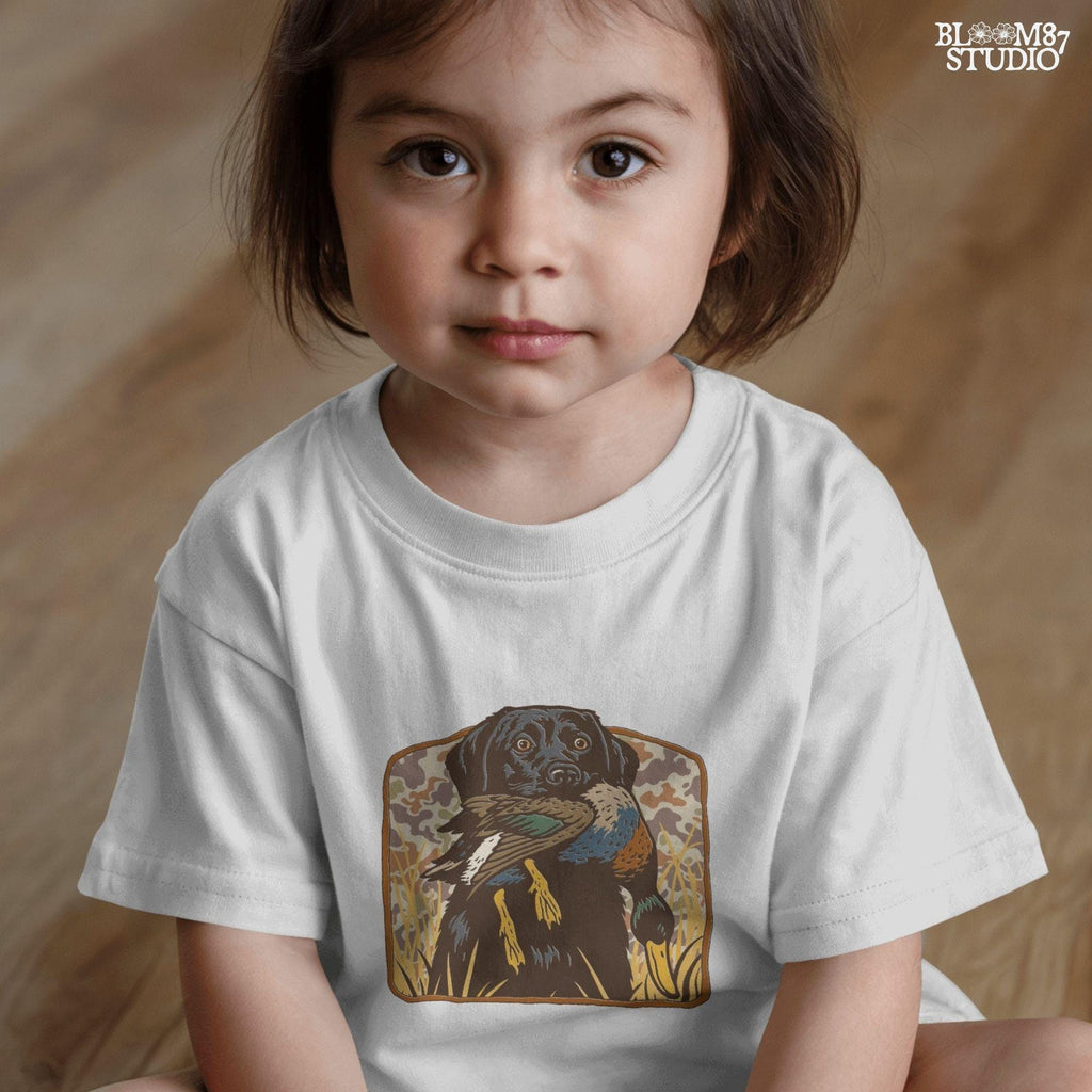 Vintage-style illustration of a black Labrador retriever holding a mallard duck in its mouth with a camouflage background, ideal for duck hunting designs.