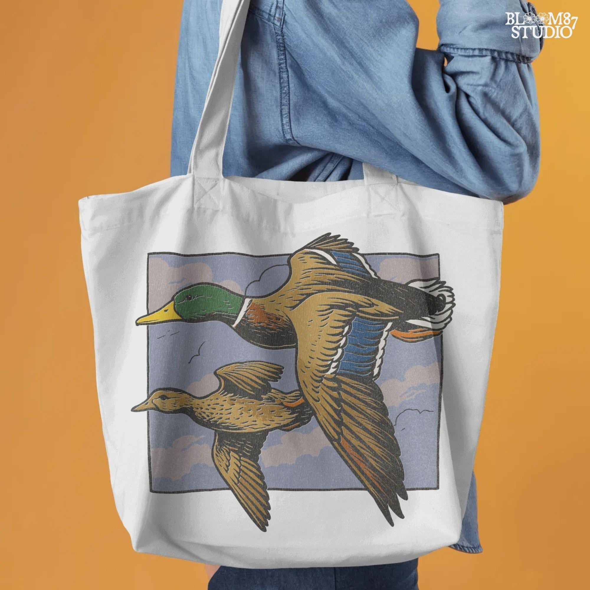 Vintage-style illustration of a flying mallard duck pair in mid-air with a cloudy sky background, ideal for rustic hunting or nature-themed designs.